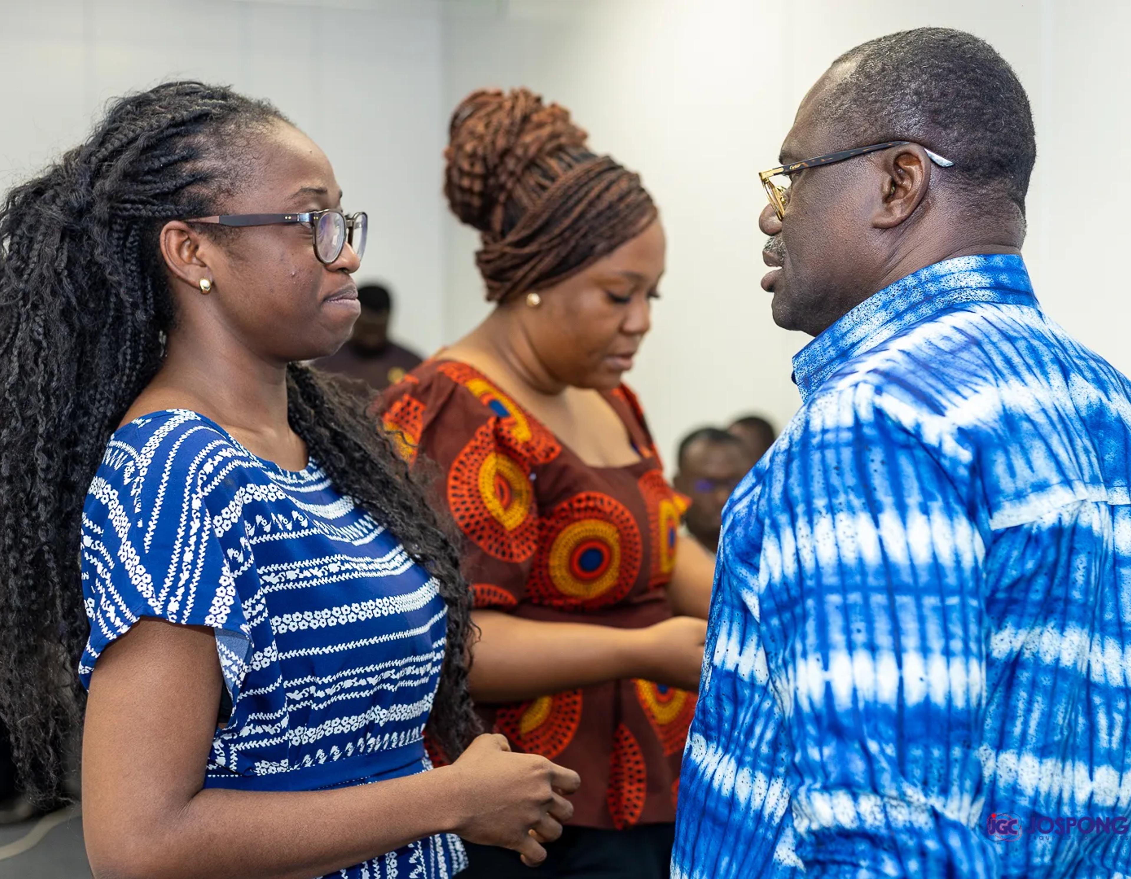Guest in blue and white shirt talks with two students