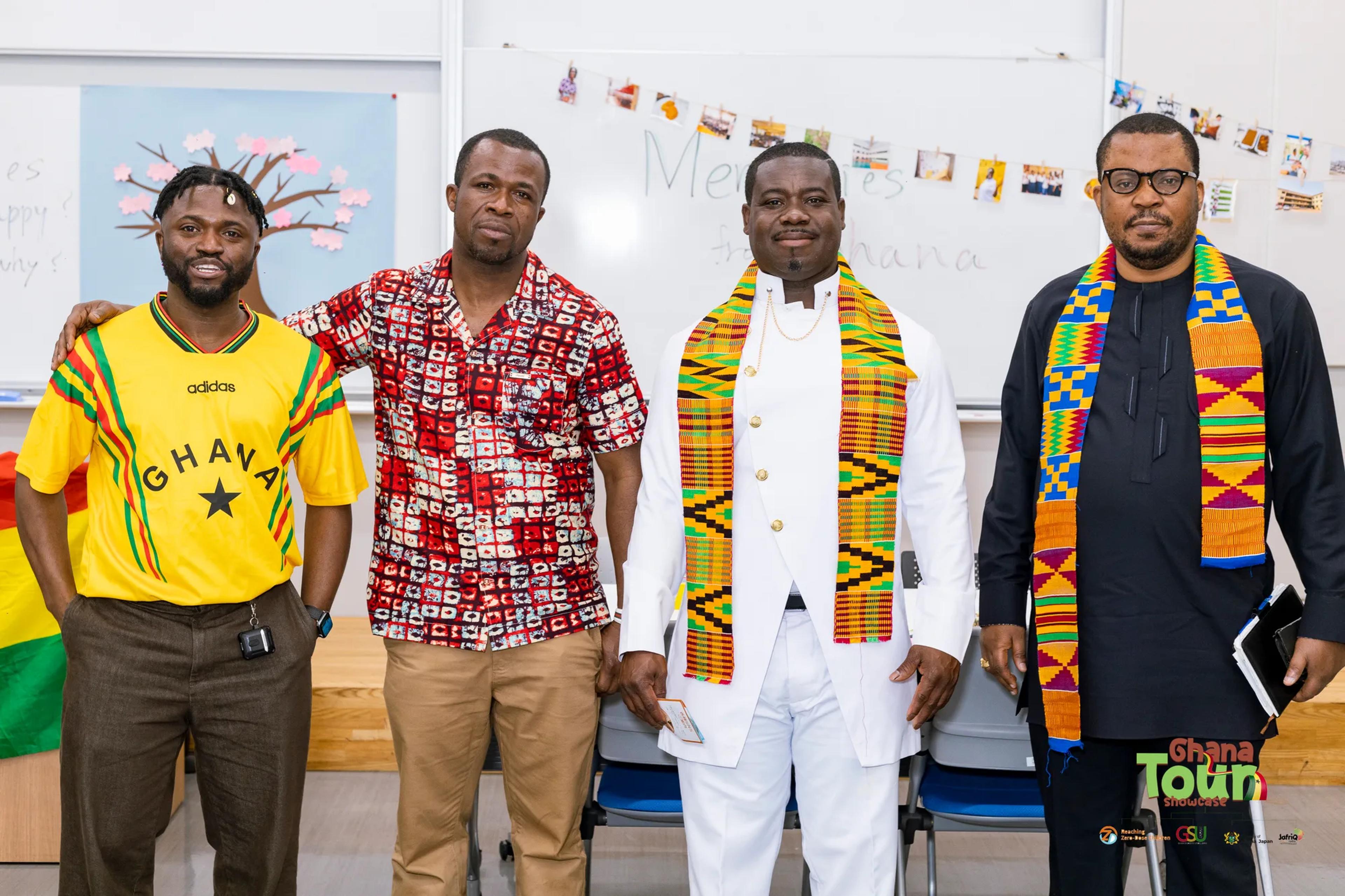Four Ghanaian men in kente stoles and a Ghana jersey pose together