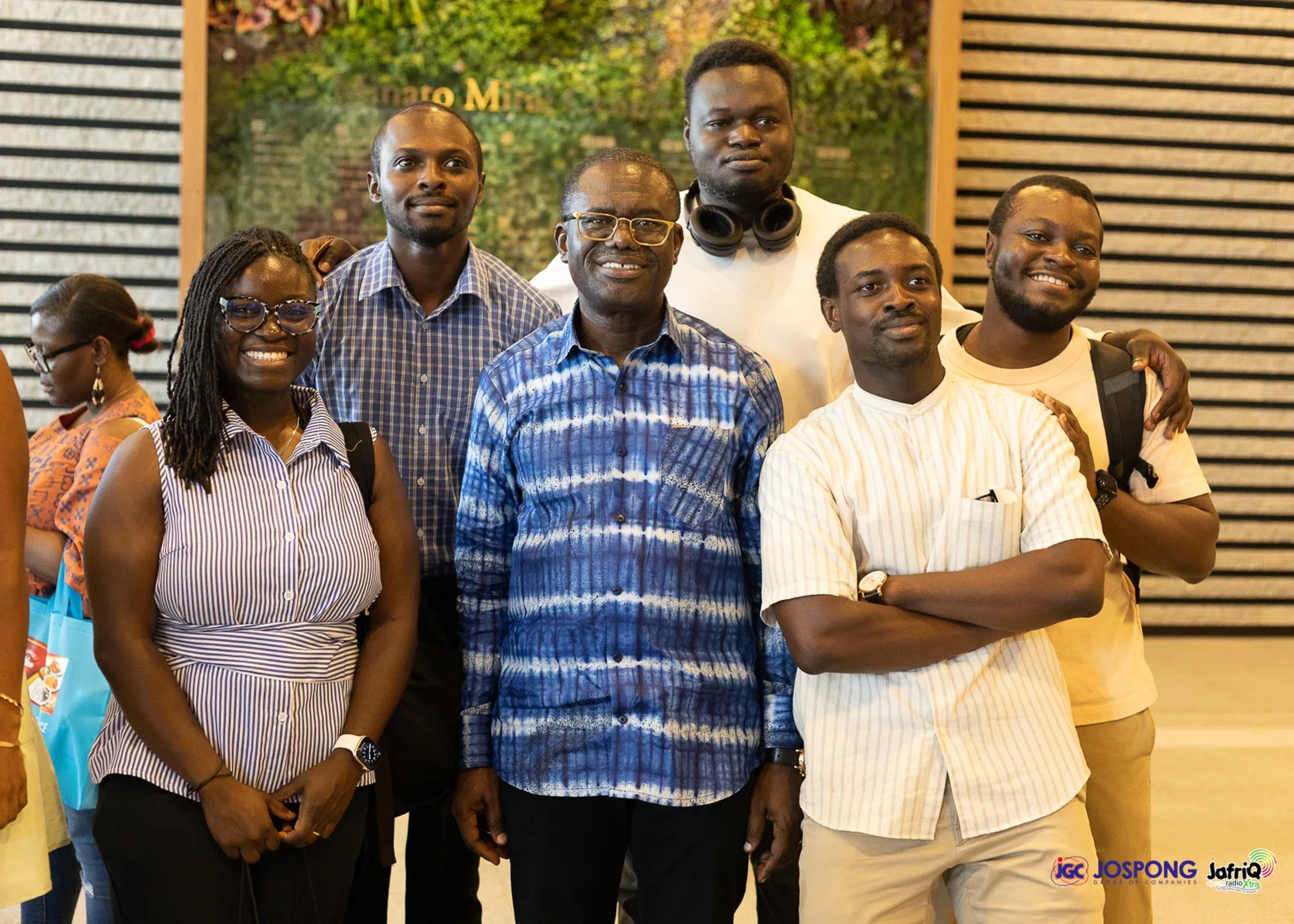 Group of students smiling with a guest in the lobby