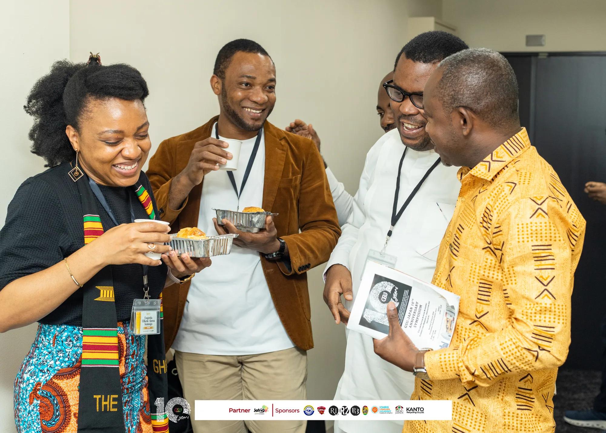 Attendees laugh together while sharing food at the reception