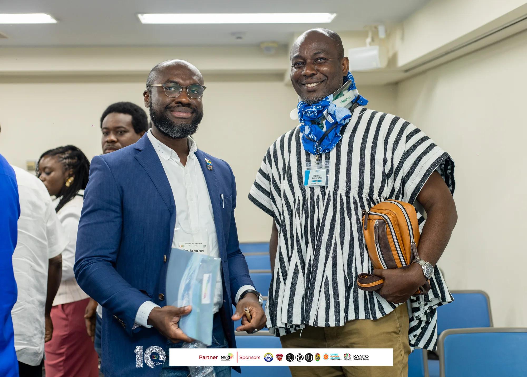 Two guests, one in a striped fugu smock, greet each other before sessions