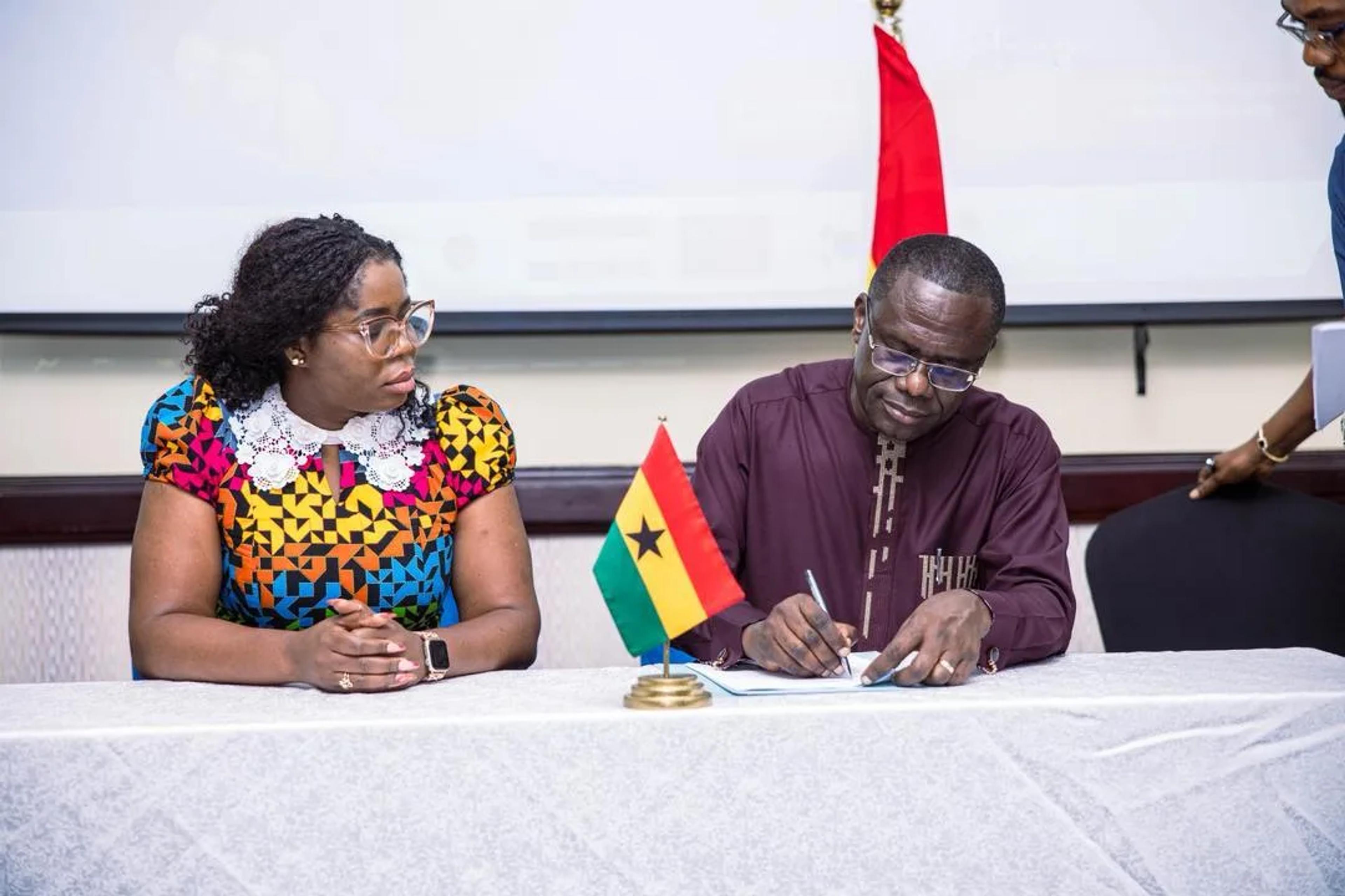 Caroline Awuye at the signing table with a Jospong Group representative