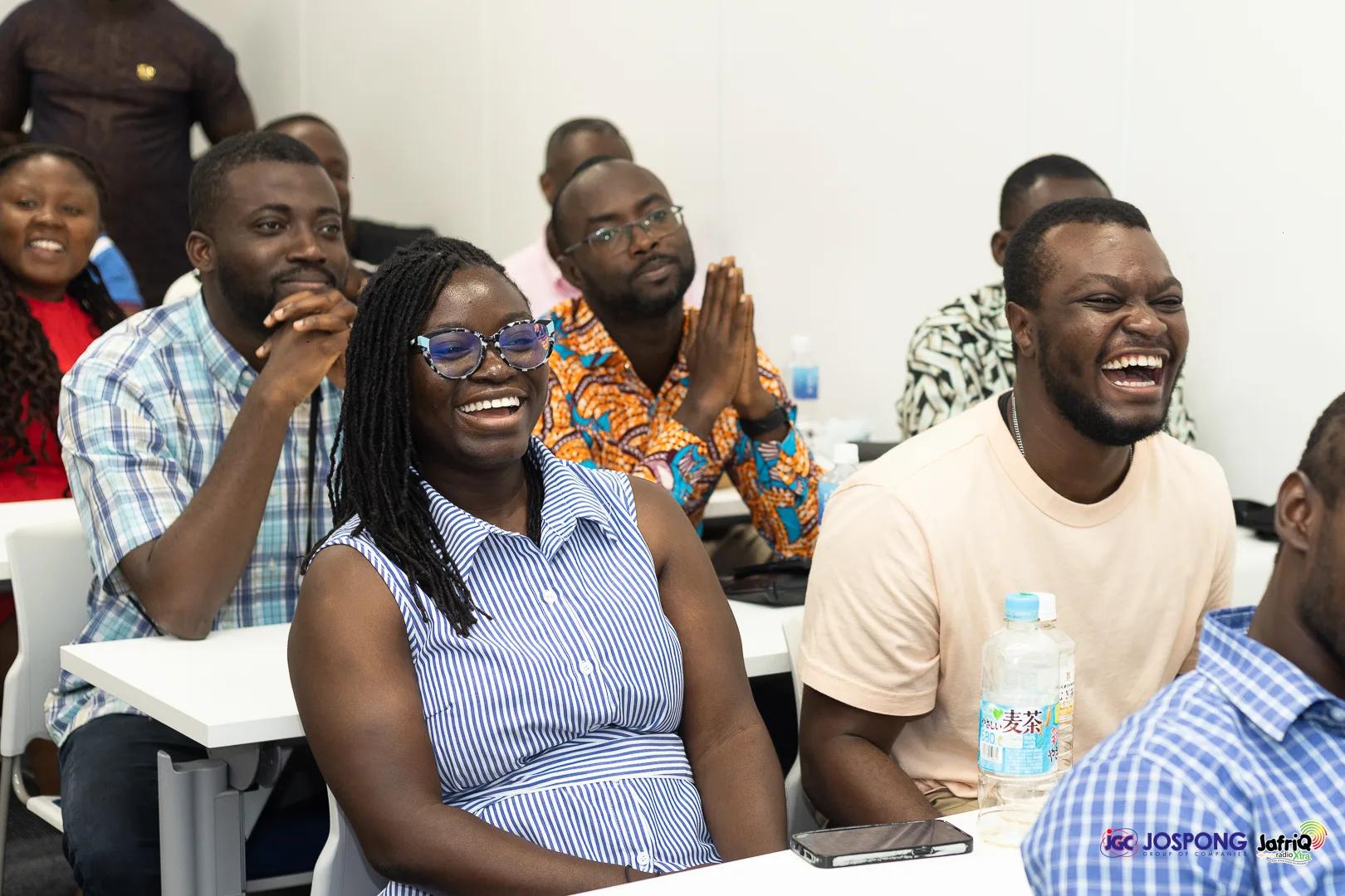 Students laughing together at seminar tables during the session