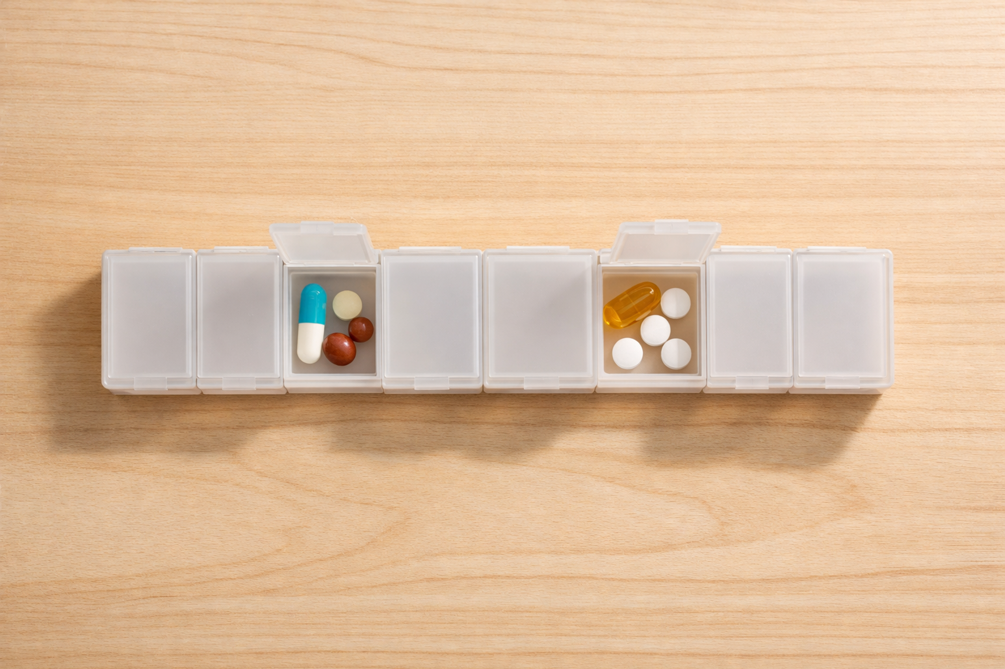 Overhead view of a weekly pill organizer with seven distinct compartments — different needs require different compartments.