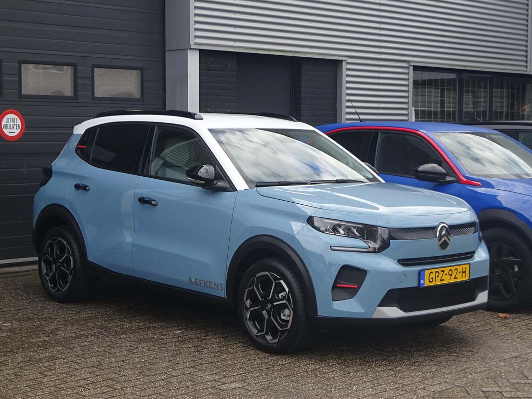 Hellblauer Citroën ë‑C3 vor Gebäude geparkt