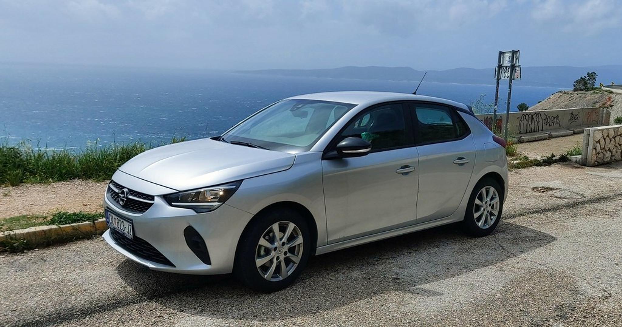 Silberner Opel Corsa am Straßenrand mit Meer im Hintergrund