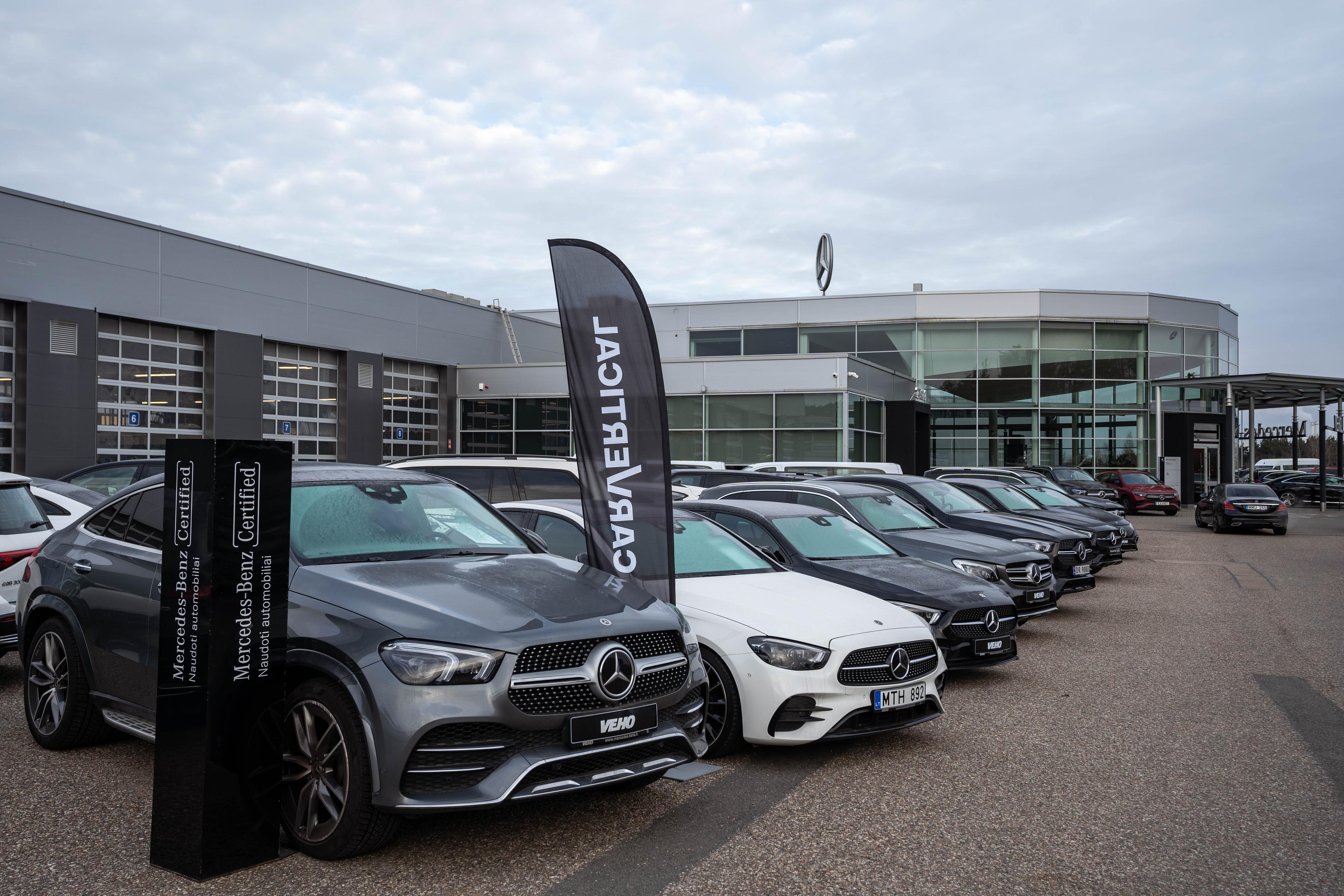 Mercedes vehicles organized in a line in front a dealership