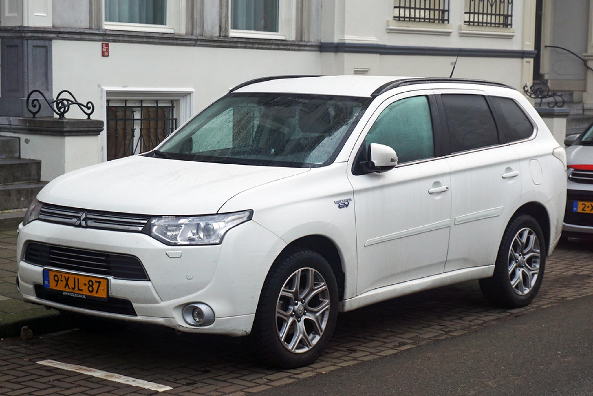 Weißer Mitsubishi Outlander PHEV am Straßenrand geparkt