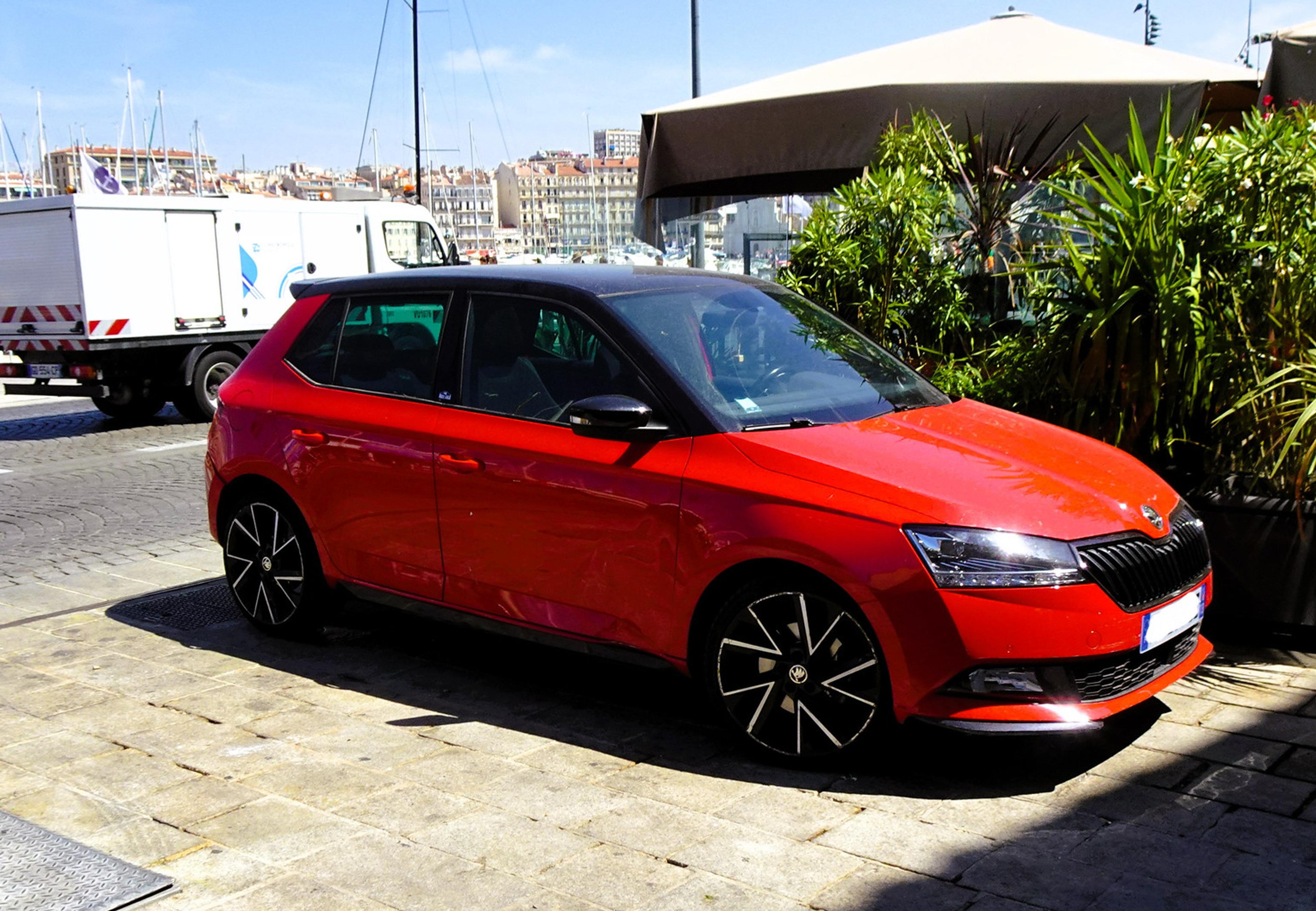 Crvena Škoda Fabia parkirana pored ulice