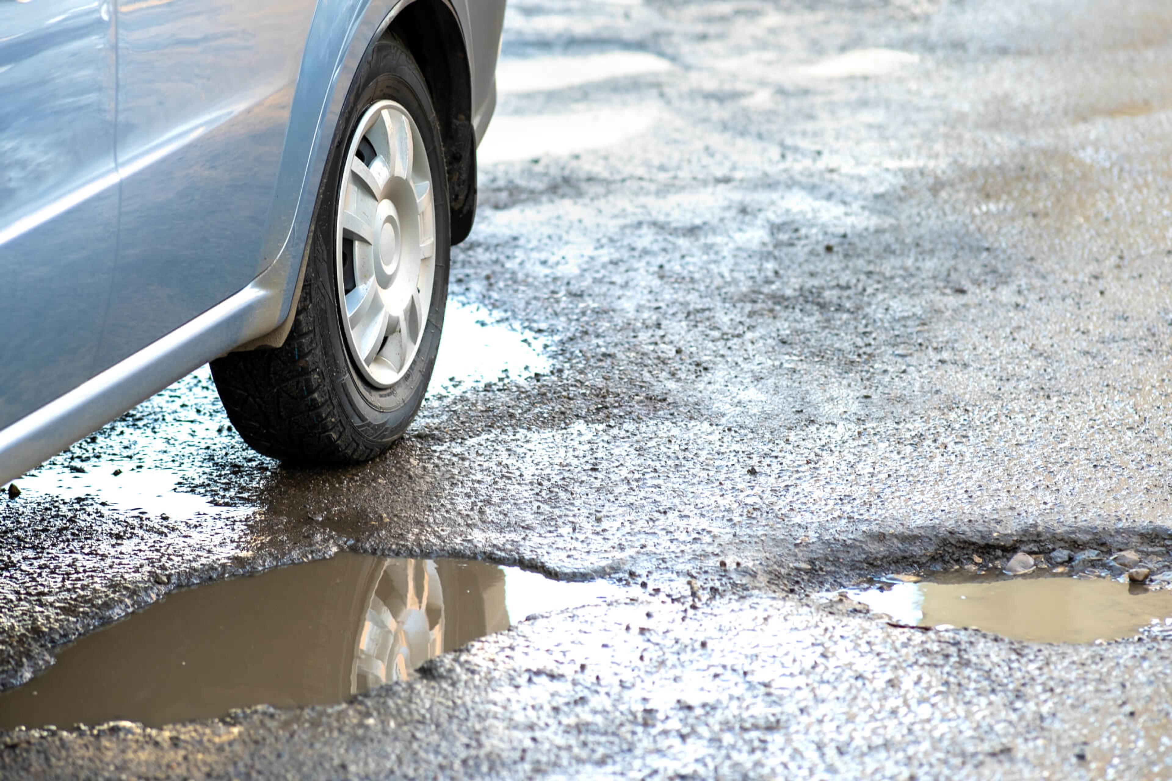 A car wheel next to potholes