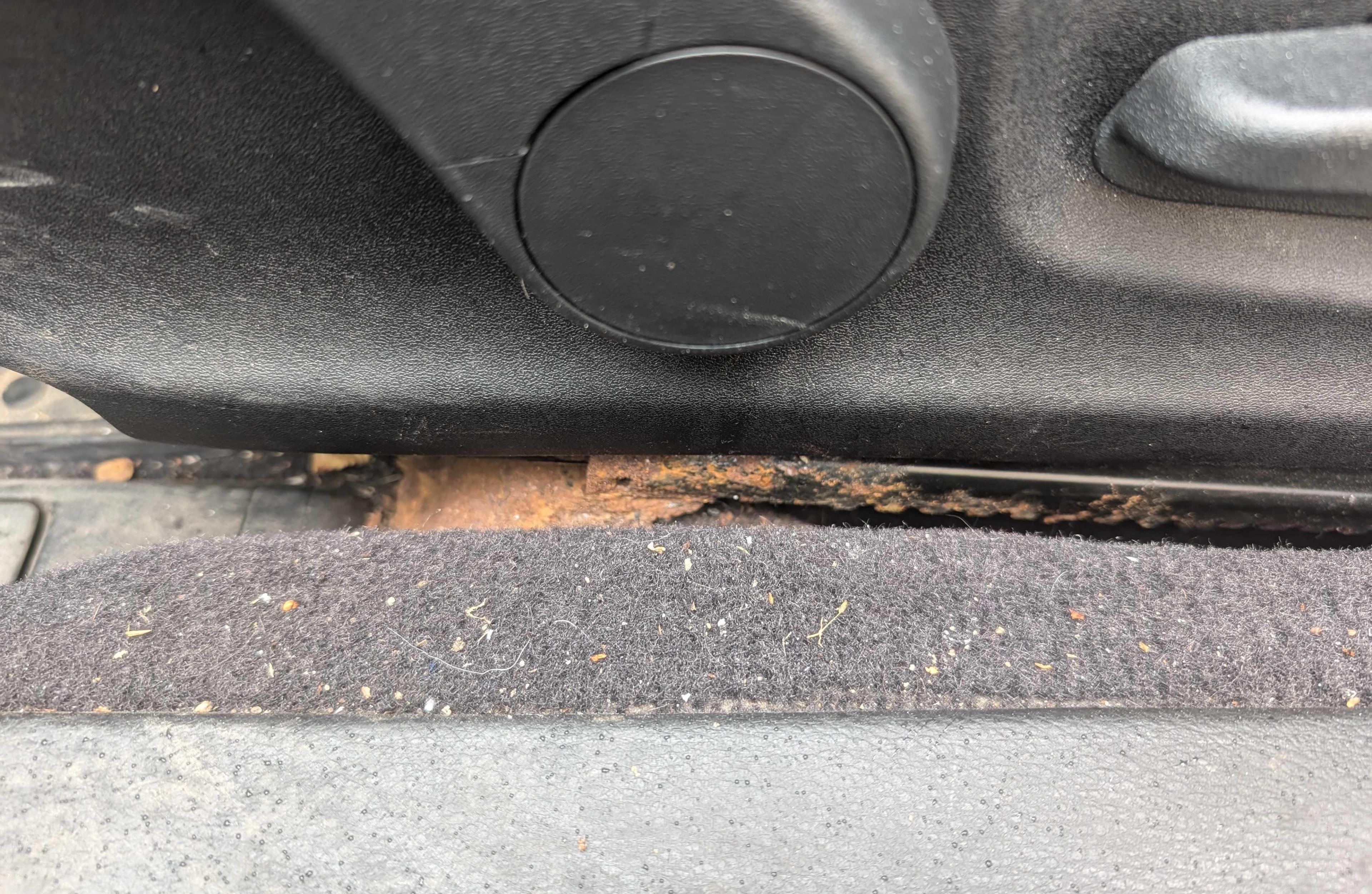 Rouille visible sous les rails du siège d’une voiture — cela pourrait être le signe d’une voiture inondée