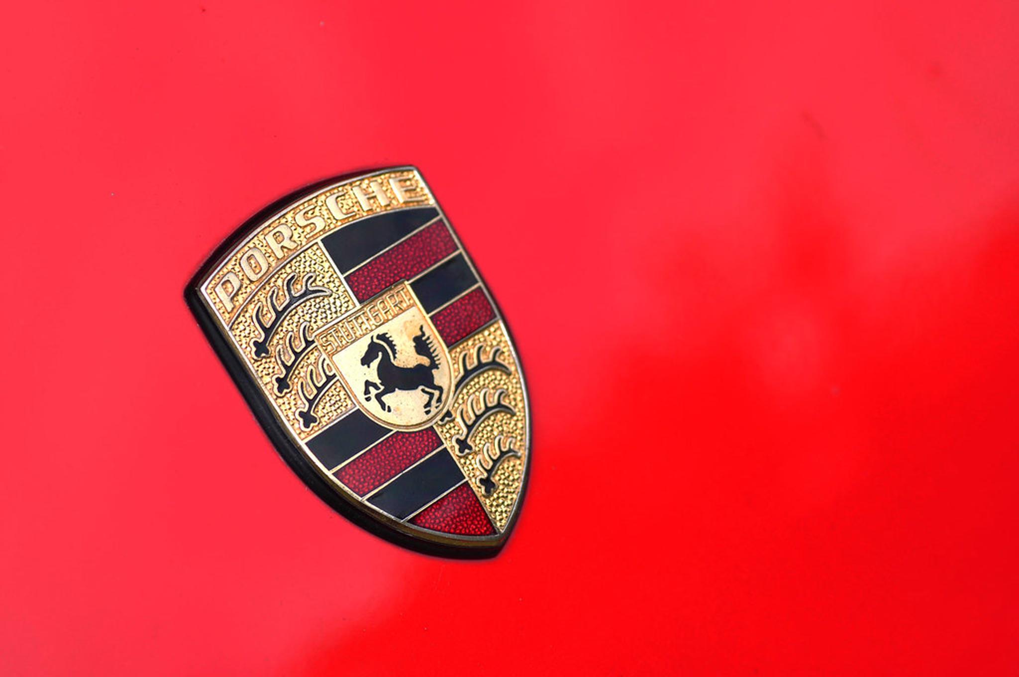 Porsche badge on a red car