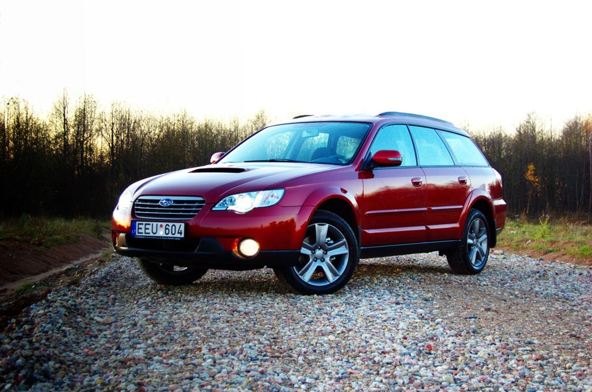 Red Subaru Outback on gravel