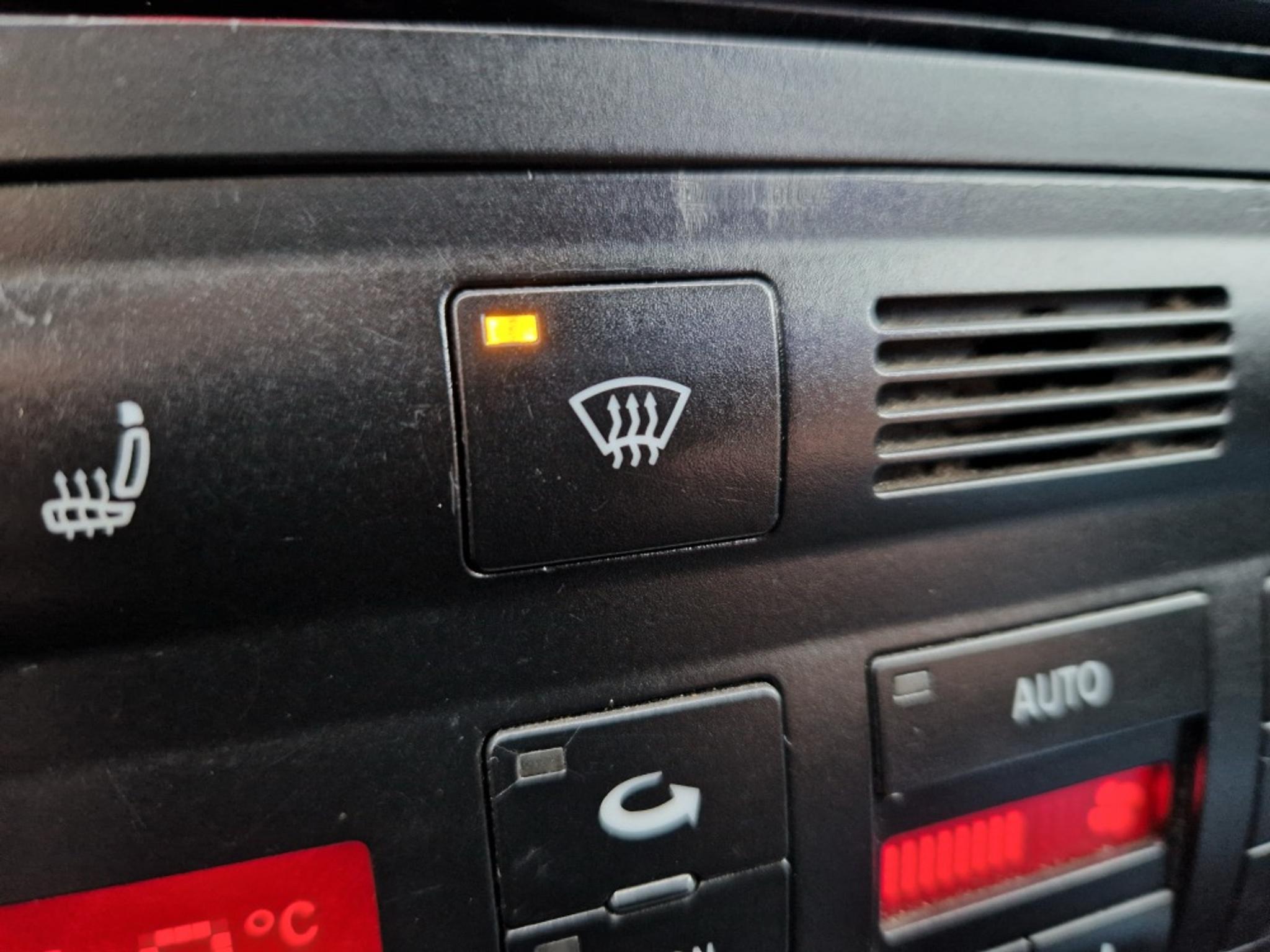 Buton de dezaburire a parbrizului într-un panou de control al climatizării