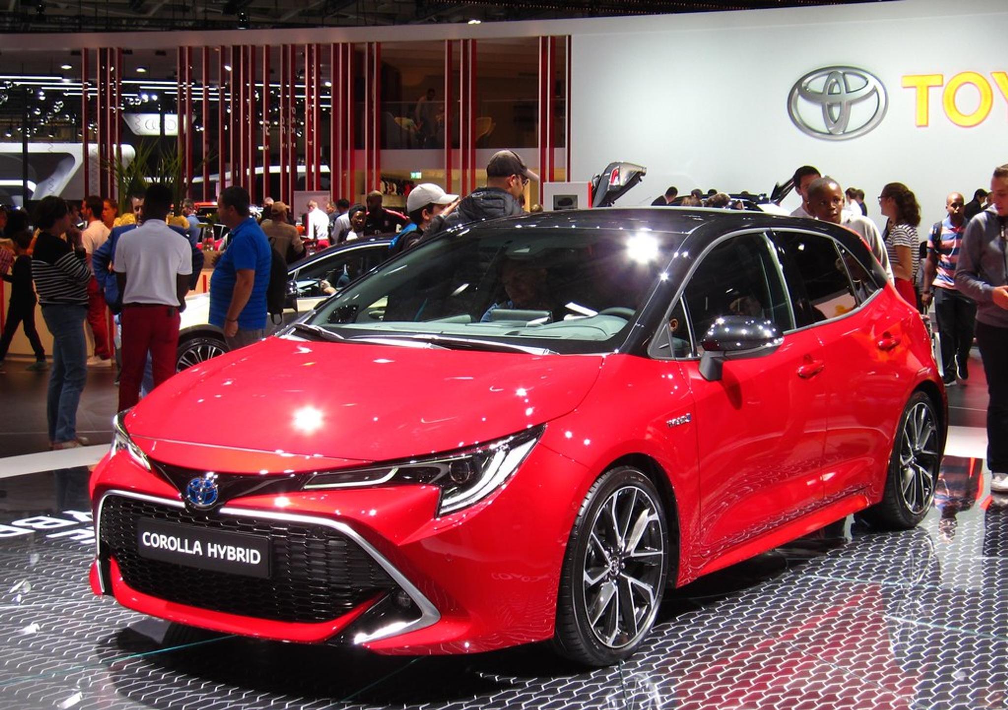 Red Toyota Corolla Hybrid in a showroom