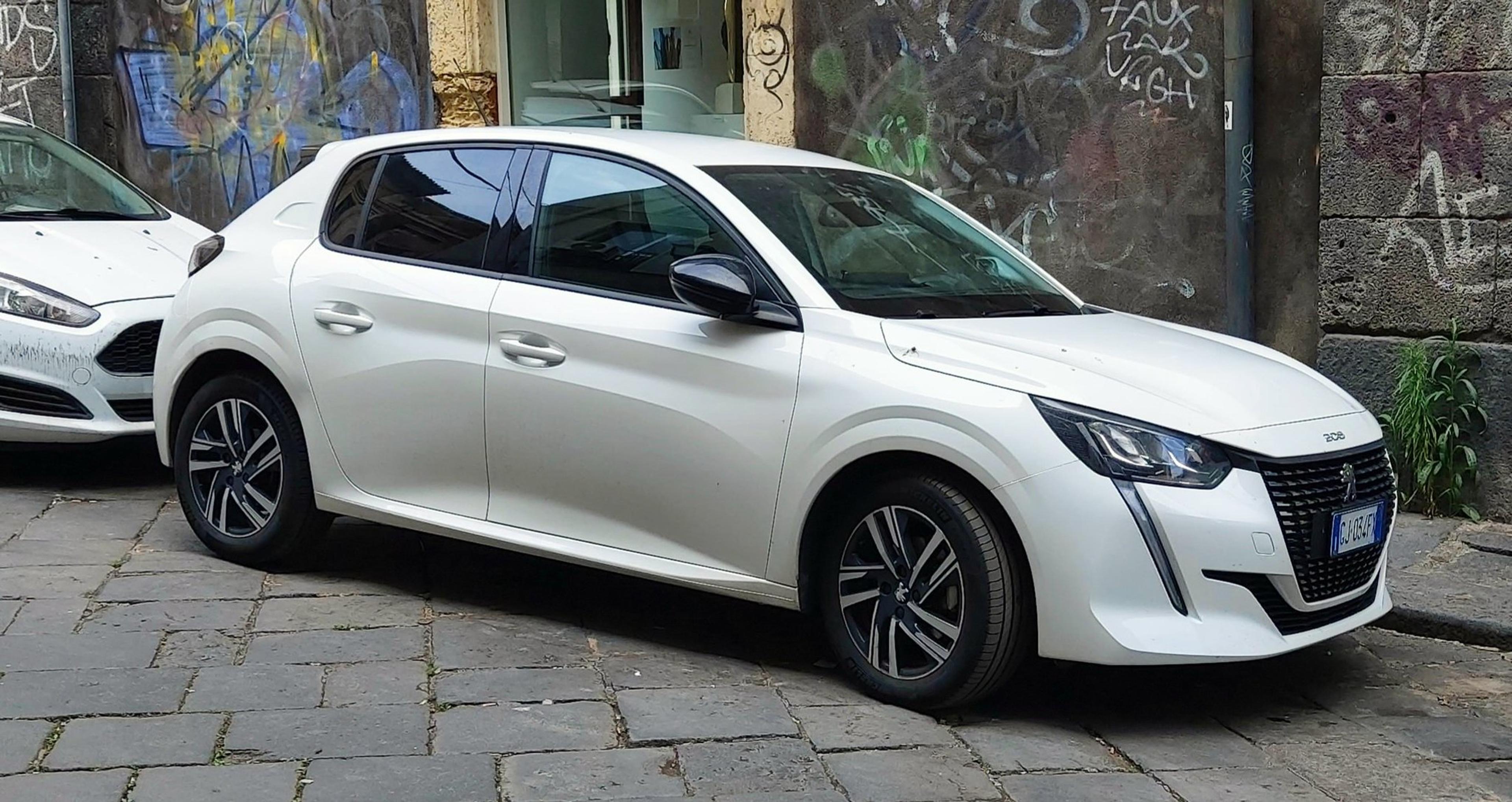 Bijeli Peugeot 208 parkiran na ulici