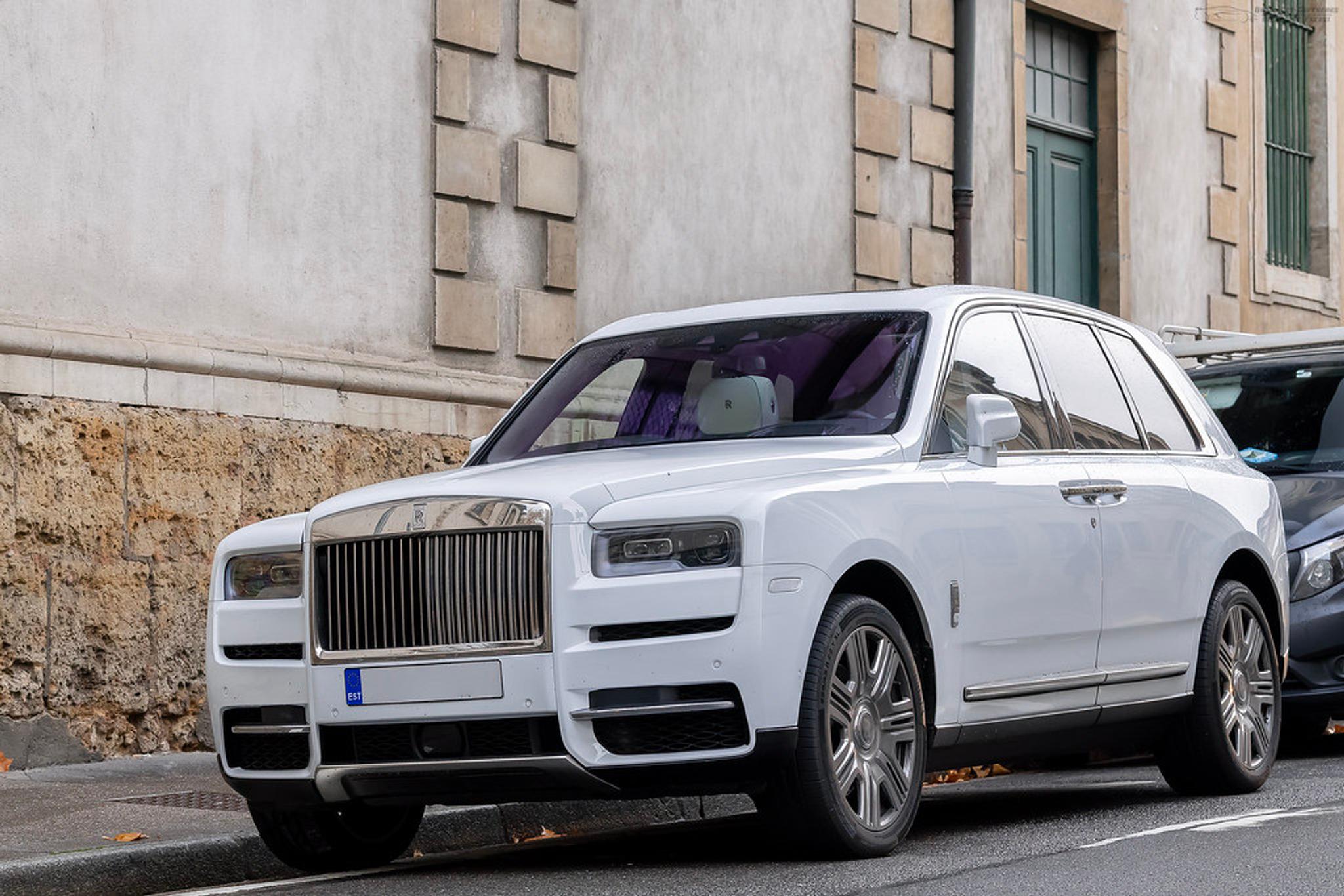 Biały Rolls-Royce Cullinan na poboczu ulicy