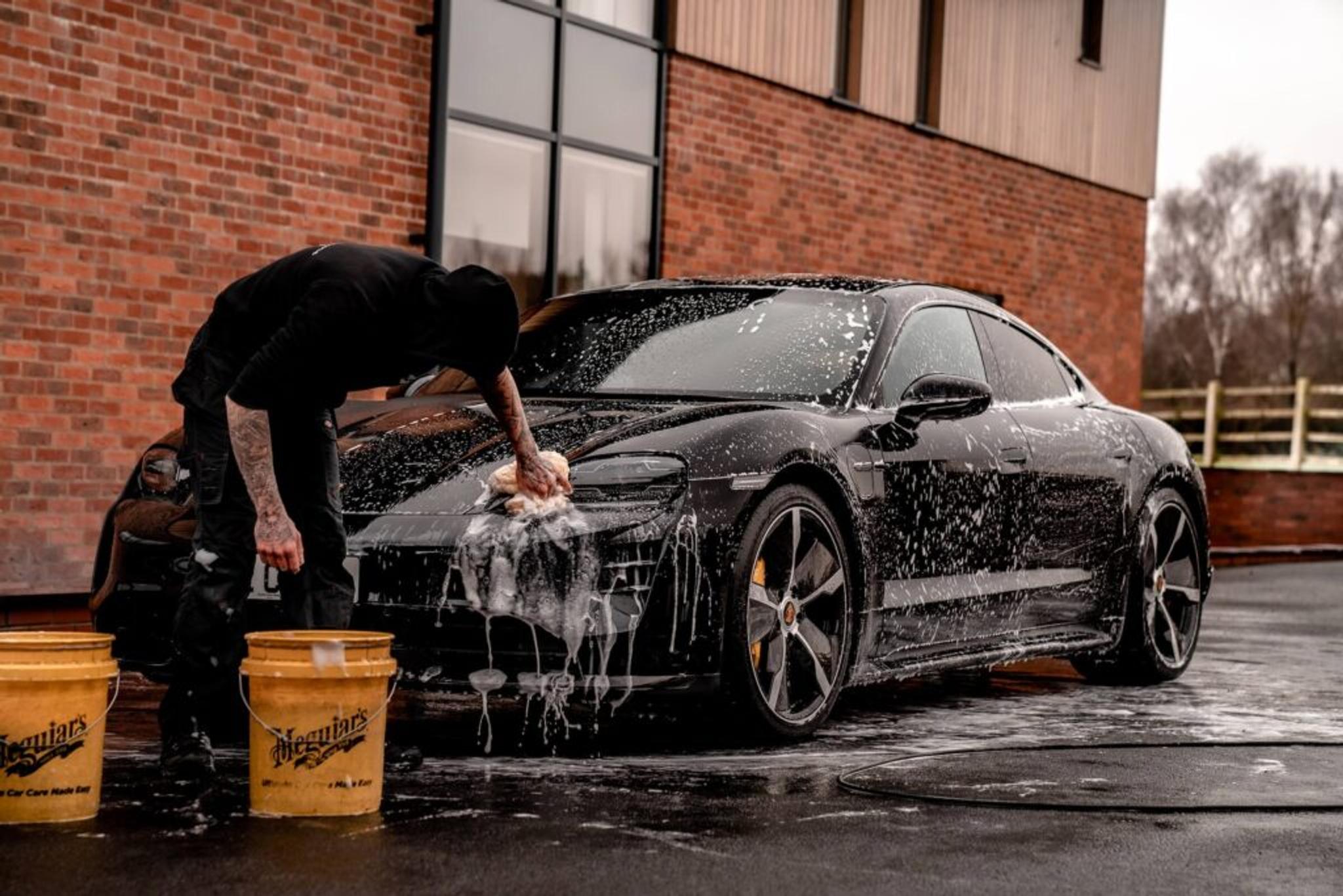 Manual cleaning of black Porsche Taycan