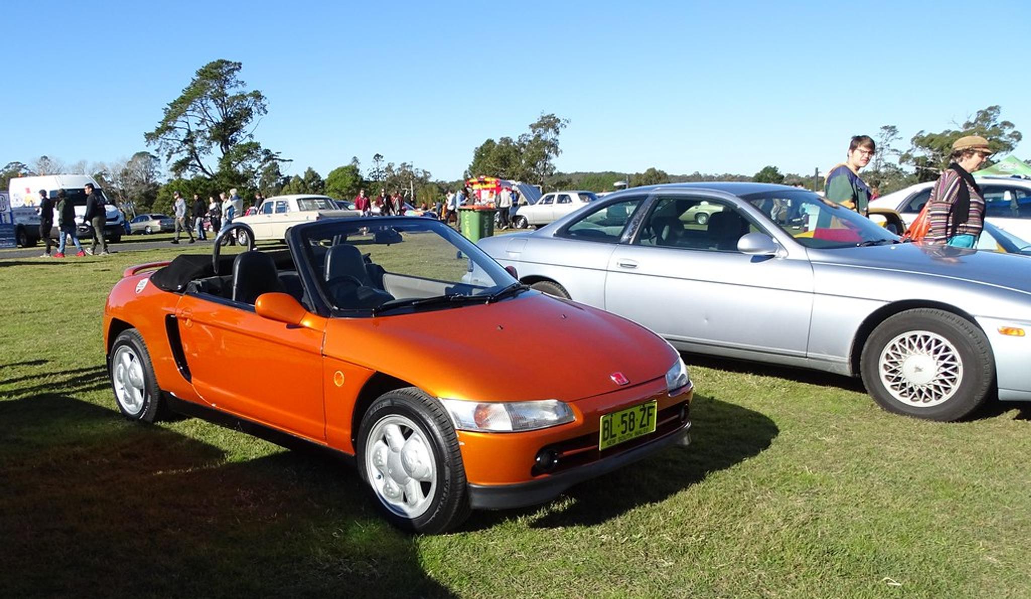 Orange Honda Beat next to a regular-sized car