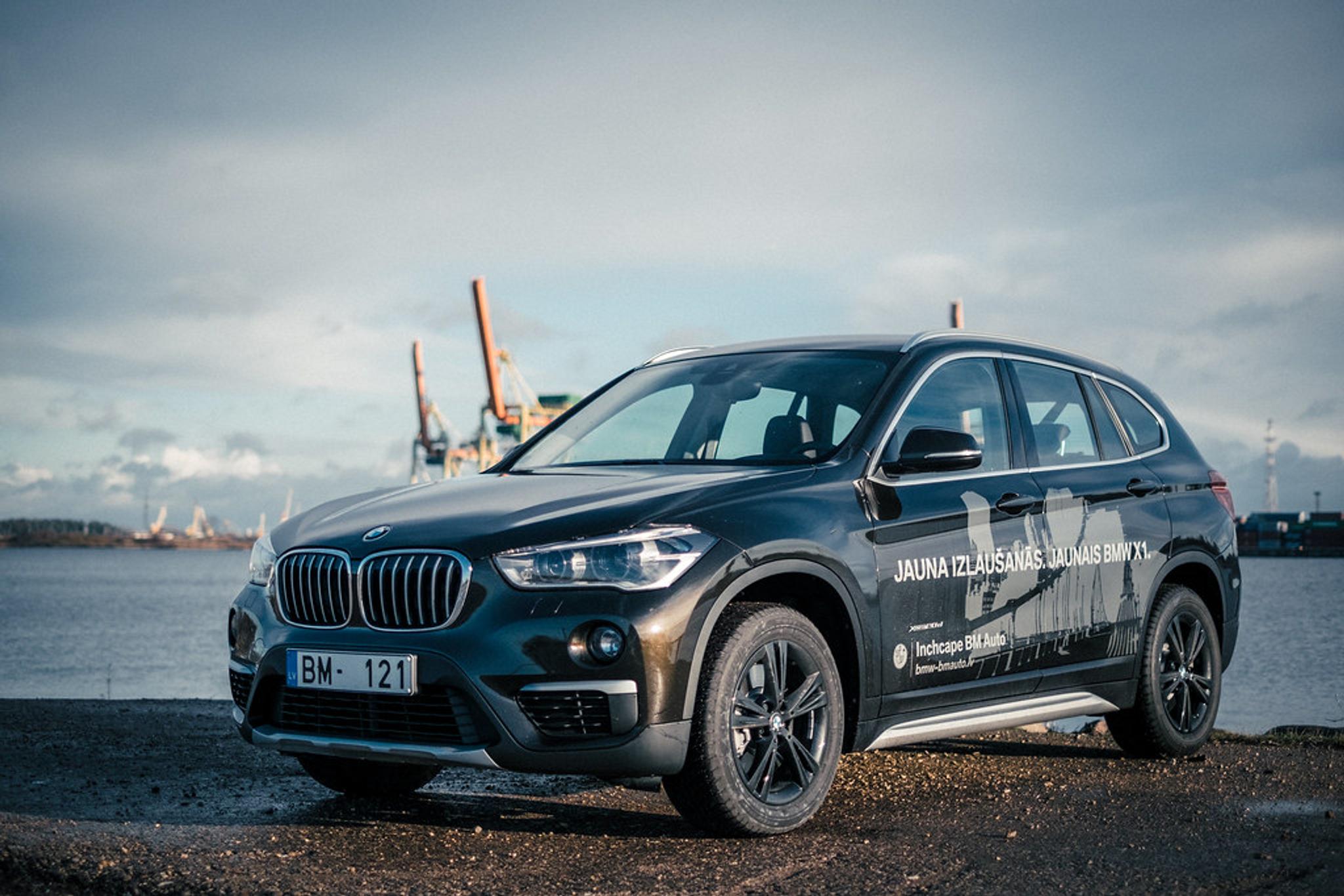 Dark brown BMW X1 next to an ocean