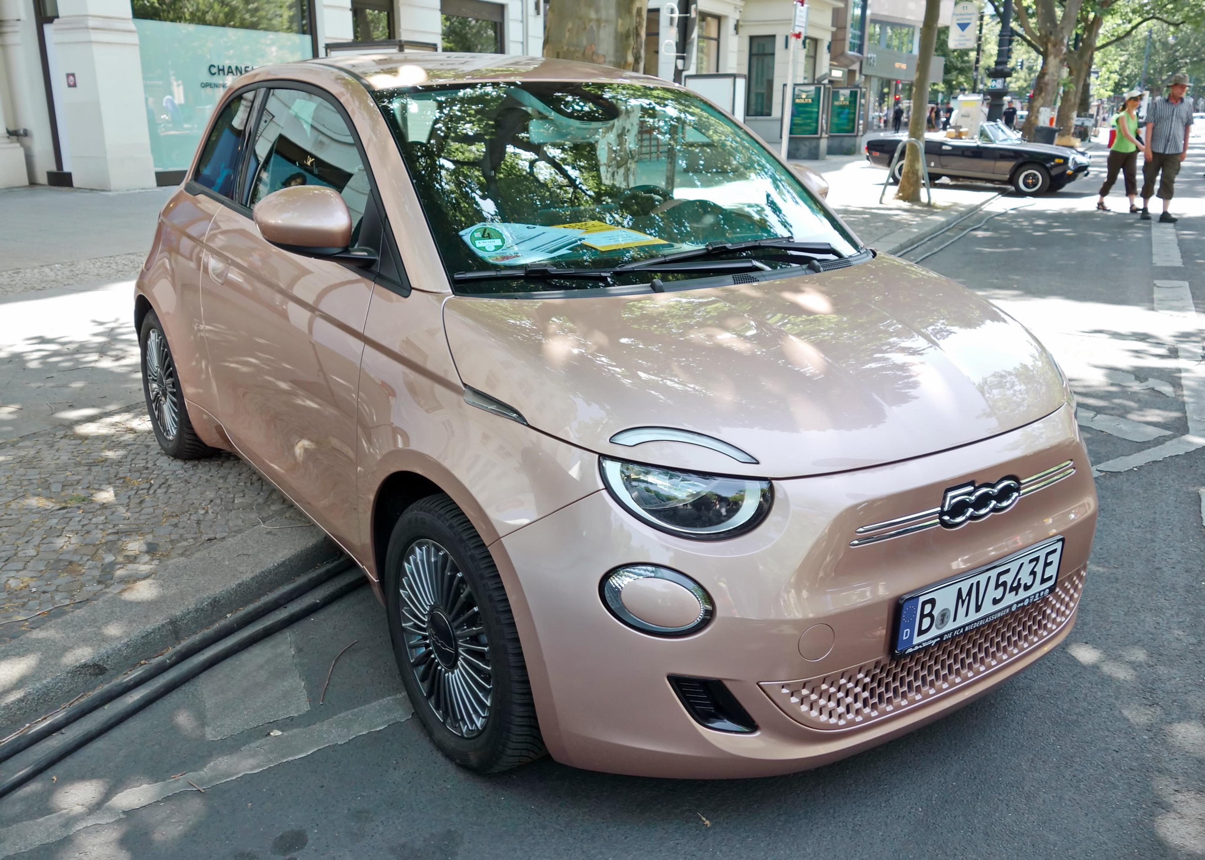 A rose ash Fiat 500e parked in the street