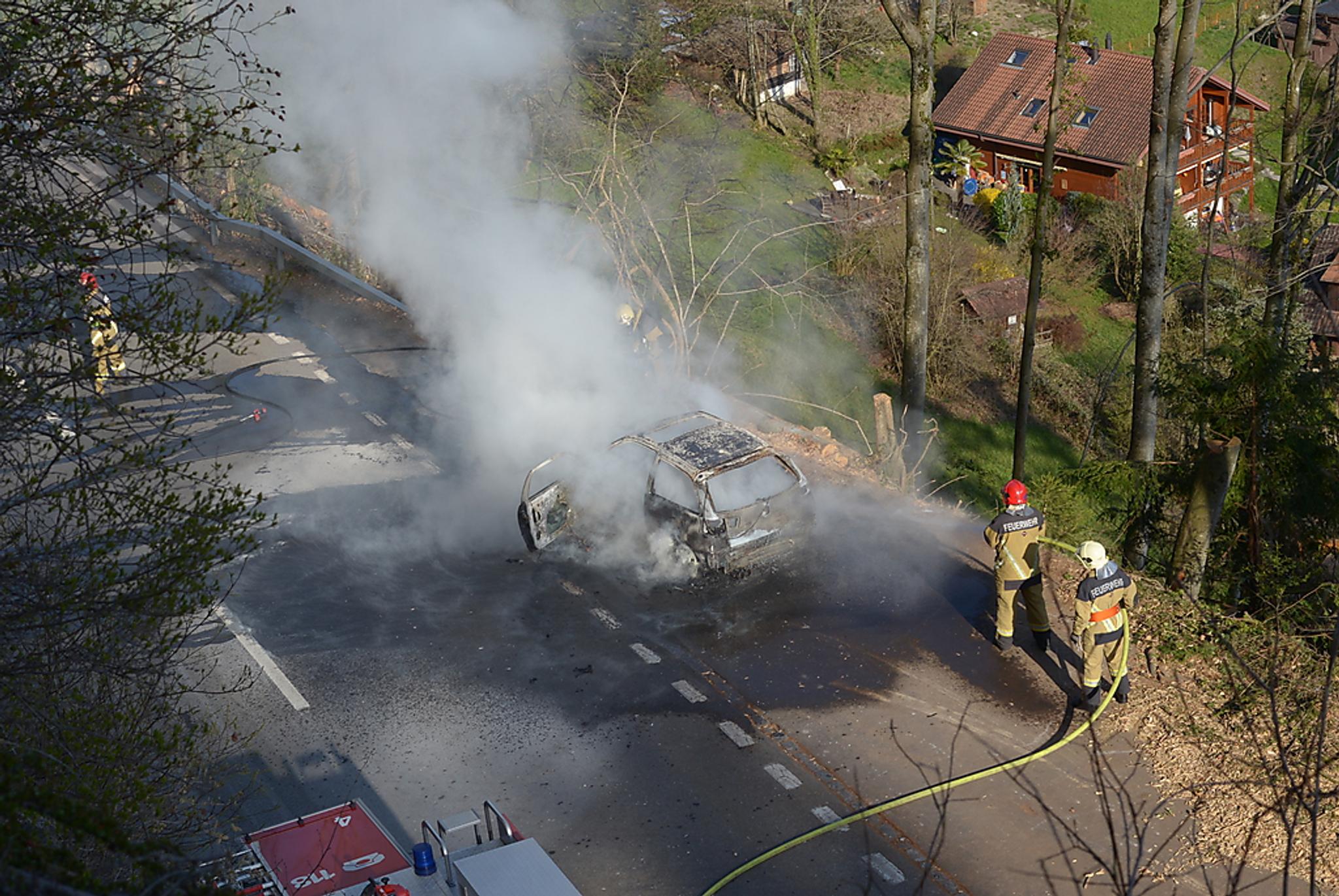 dwóch strażaków gaśnie pożar samochodu