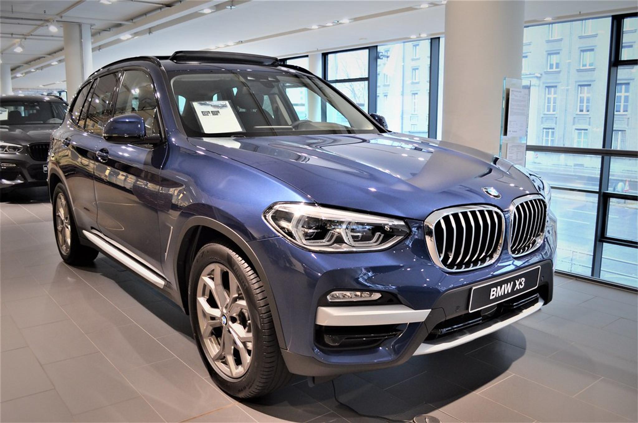 Metallic blue BMW X3 parked in a showroom