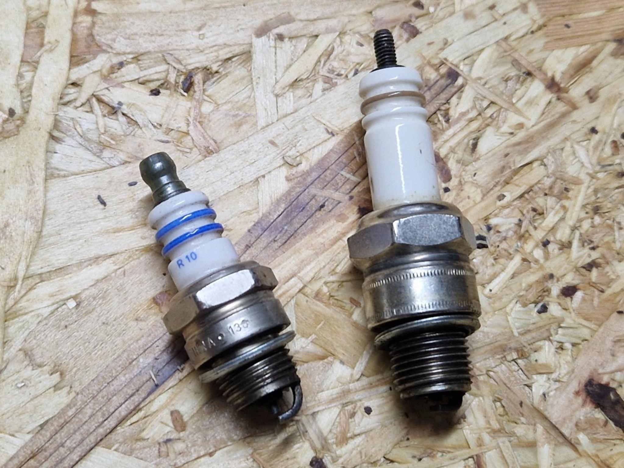 Două bujii diferite plasate pe o placă OSB