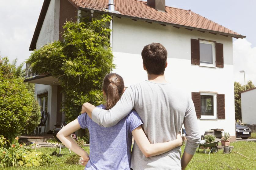 couple standing in front of the house