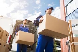 two men carrying moving boxes