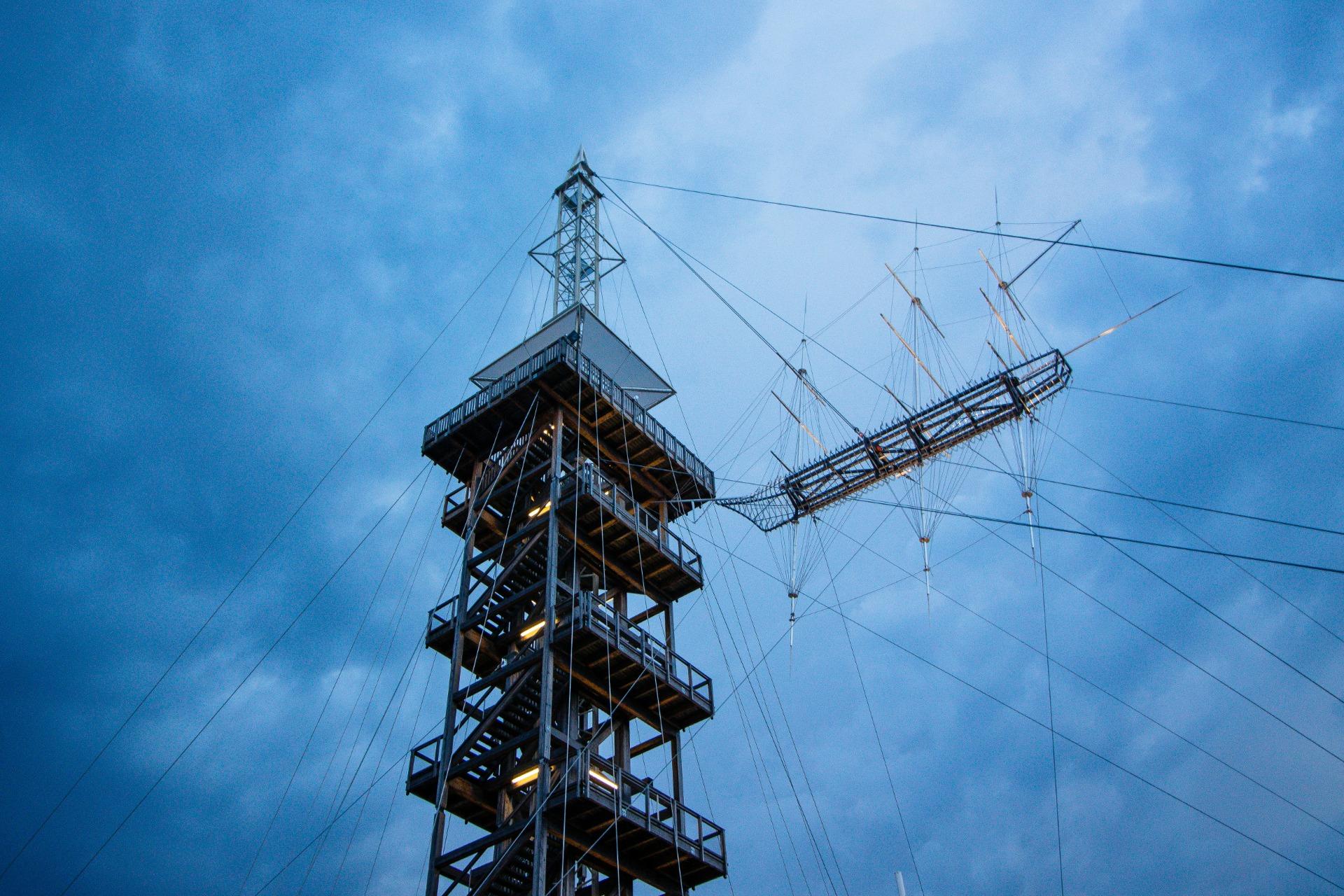Sample photo: a timber lookout tower with guy wires against a dark sky