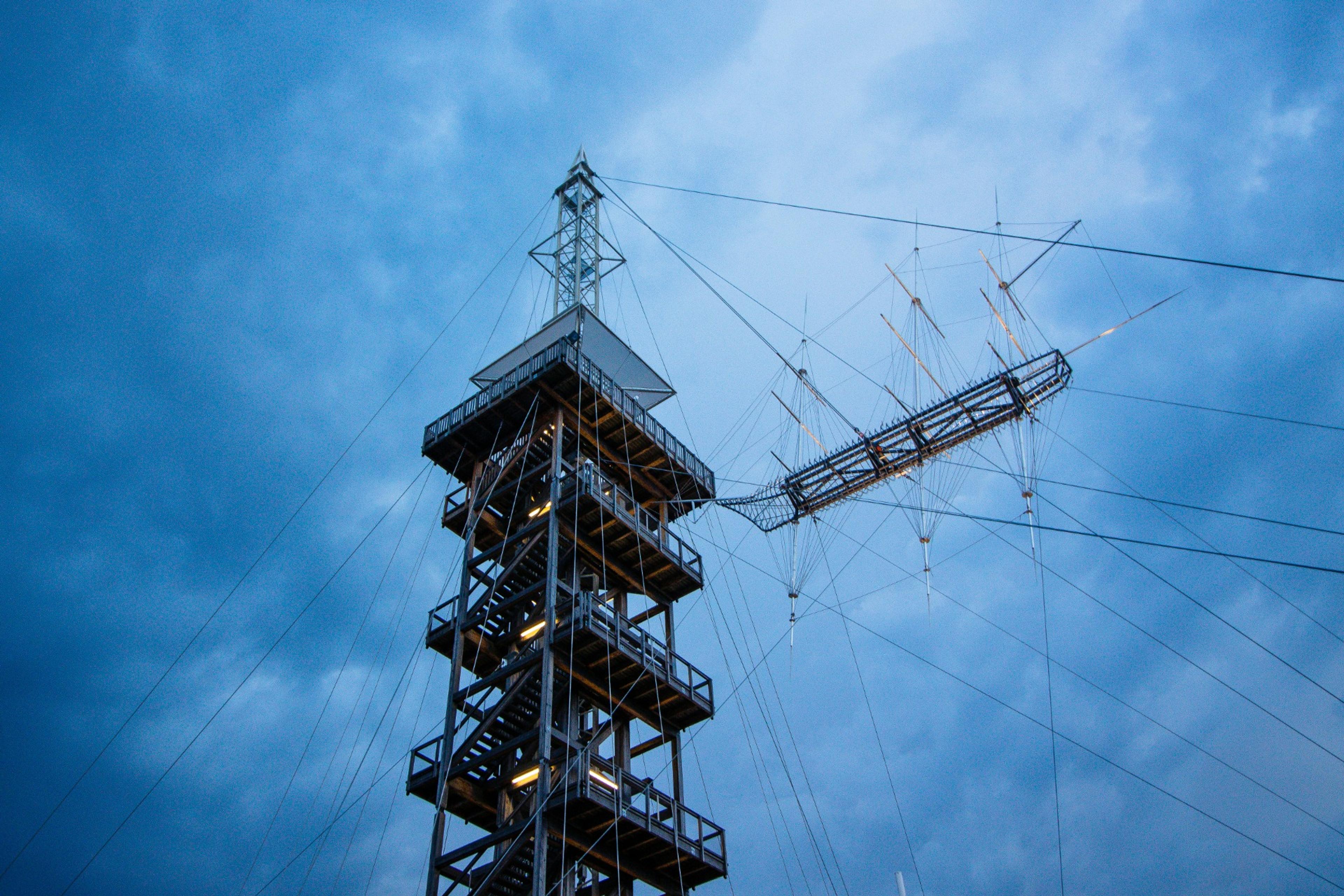 Sample photo: a timber lookout tower with guy wires against a dark sky