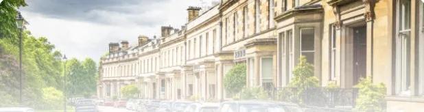 A terrace of houses with parked cars