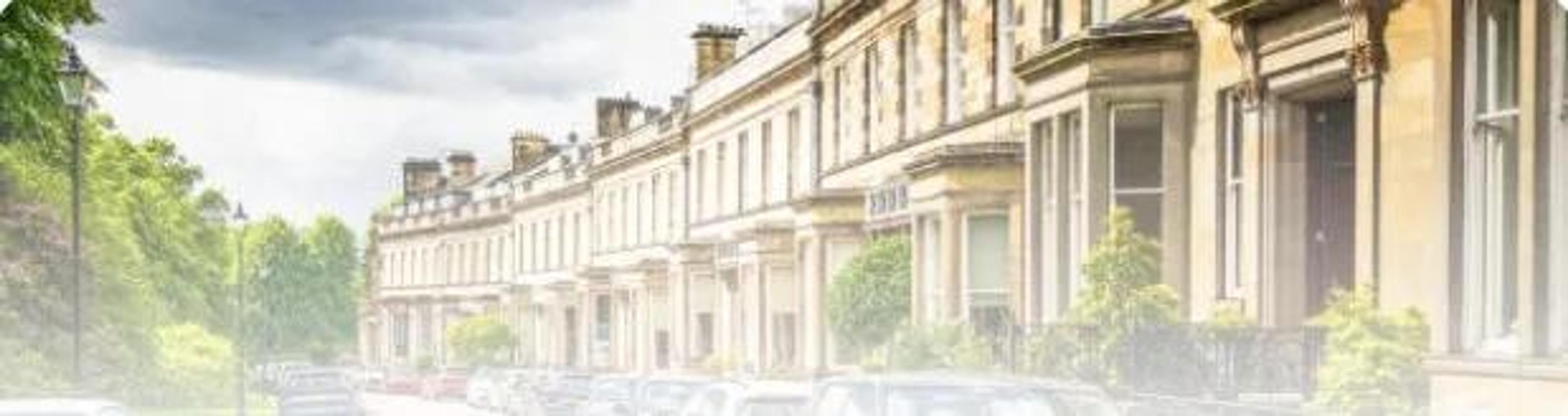 A terrace of houses with parked cars