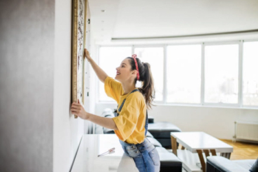 A woman hanging up a painting