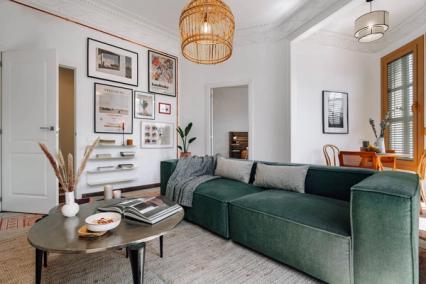 living room with green couch and wall art filling the space