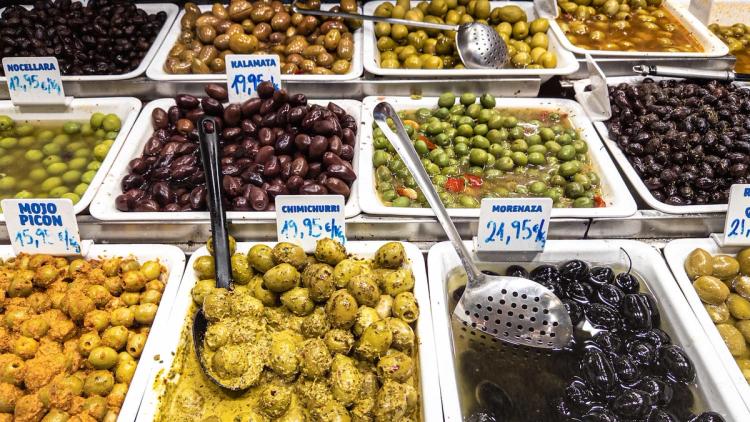 Display of many types of olives for purchase at a market