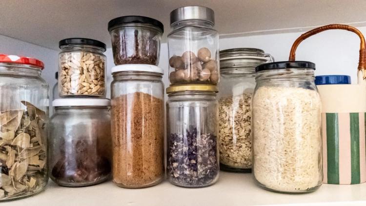 Jars in cupboard filled with spices and dried food