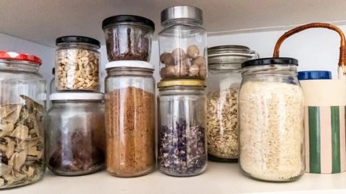 Jars in cupboard filled with spices and dried food