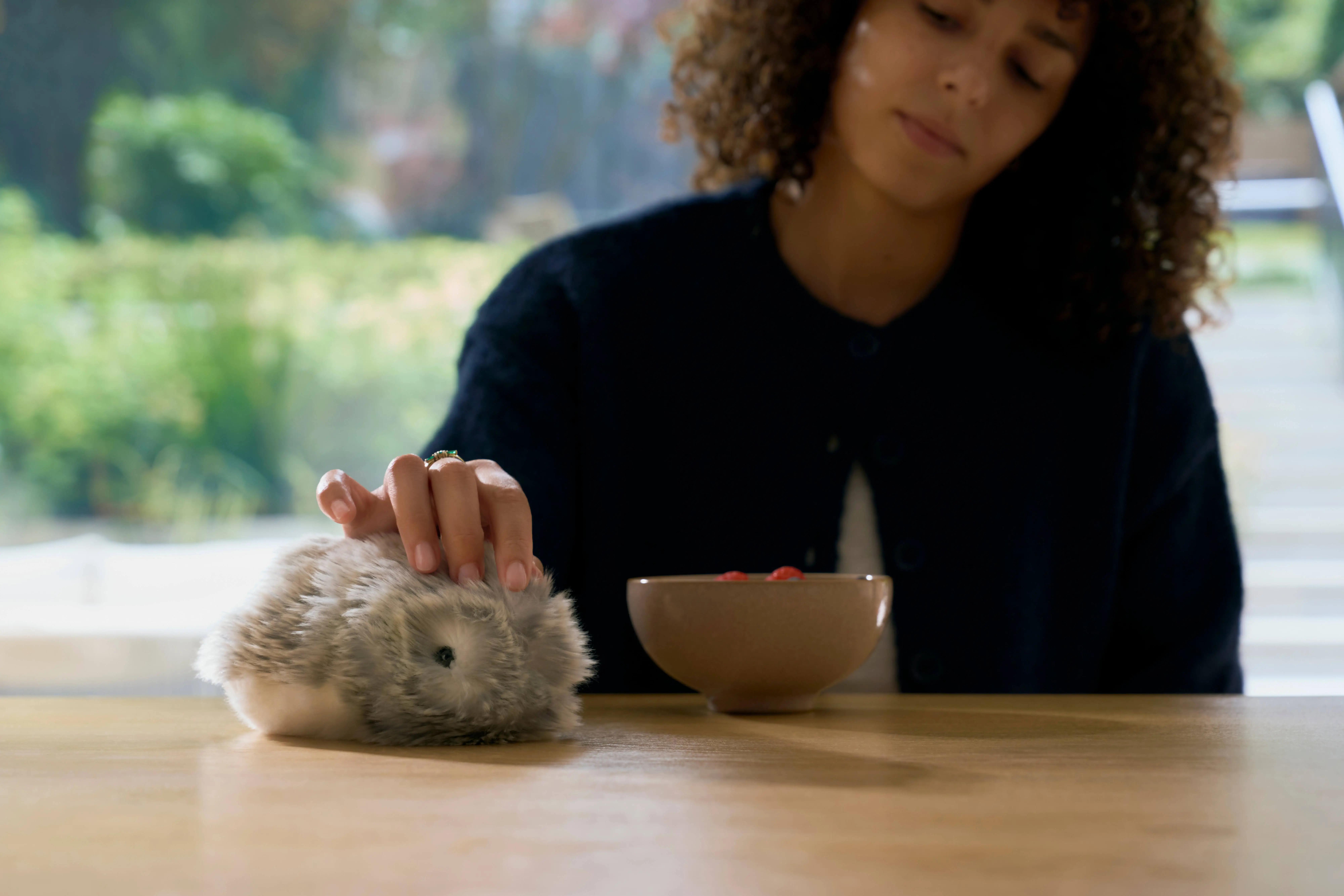 Woman stroking Moflin, CASIO's AI Pet