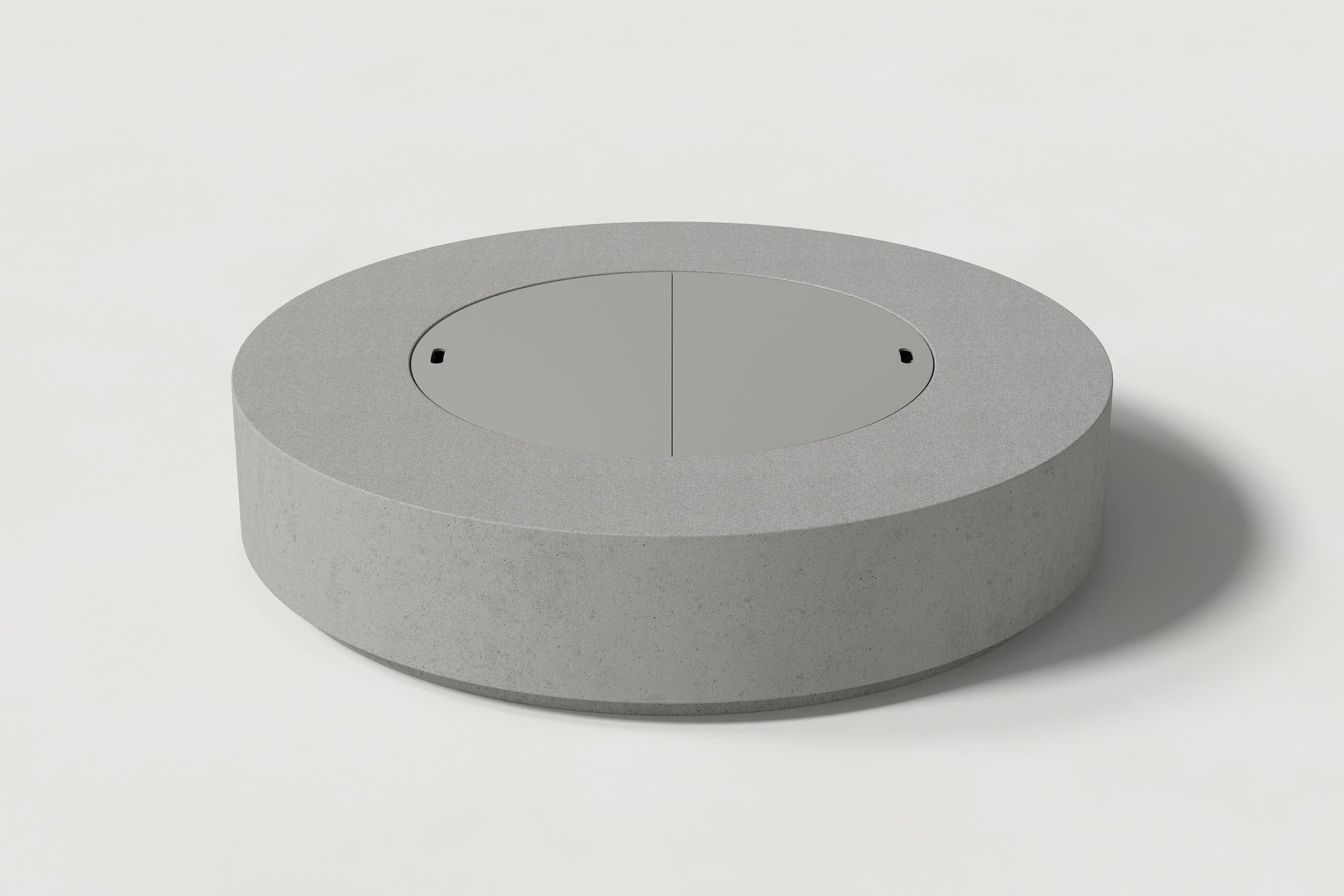 Low cylindrical grey concrete fire pit with thick walls and a central circular well. Mid-range angle shows the well covered with matching cover with handles against a white background.