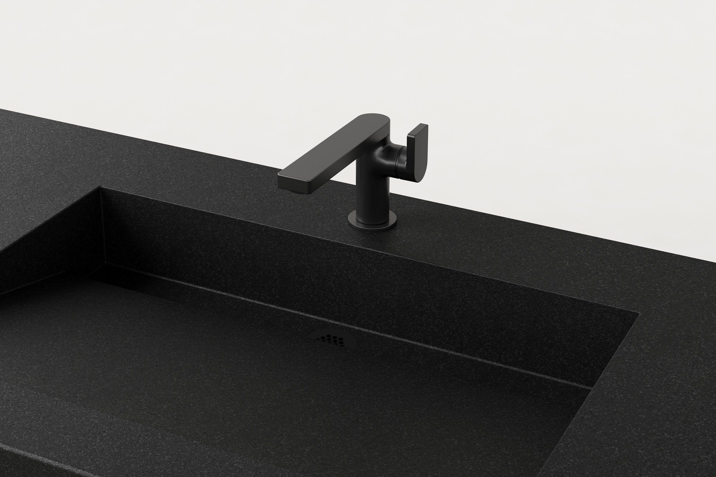 Detail view of the Storm finish concrete sink basin with matte black faucet and integrated drain.
