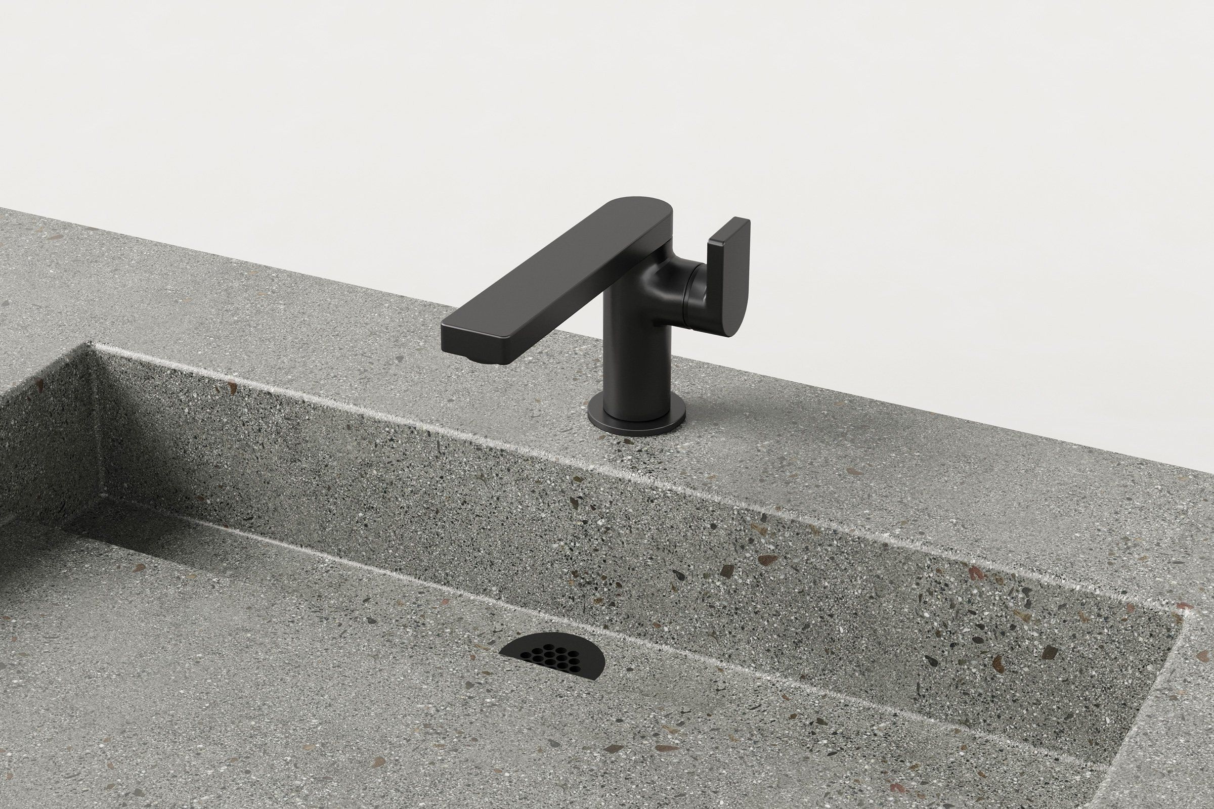 Close-up of matte black faucet and integrated drain on concrete double-basin sink.