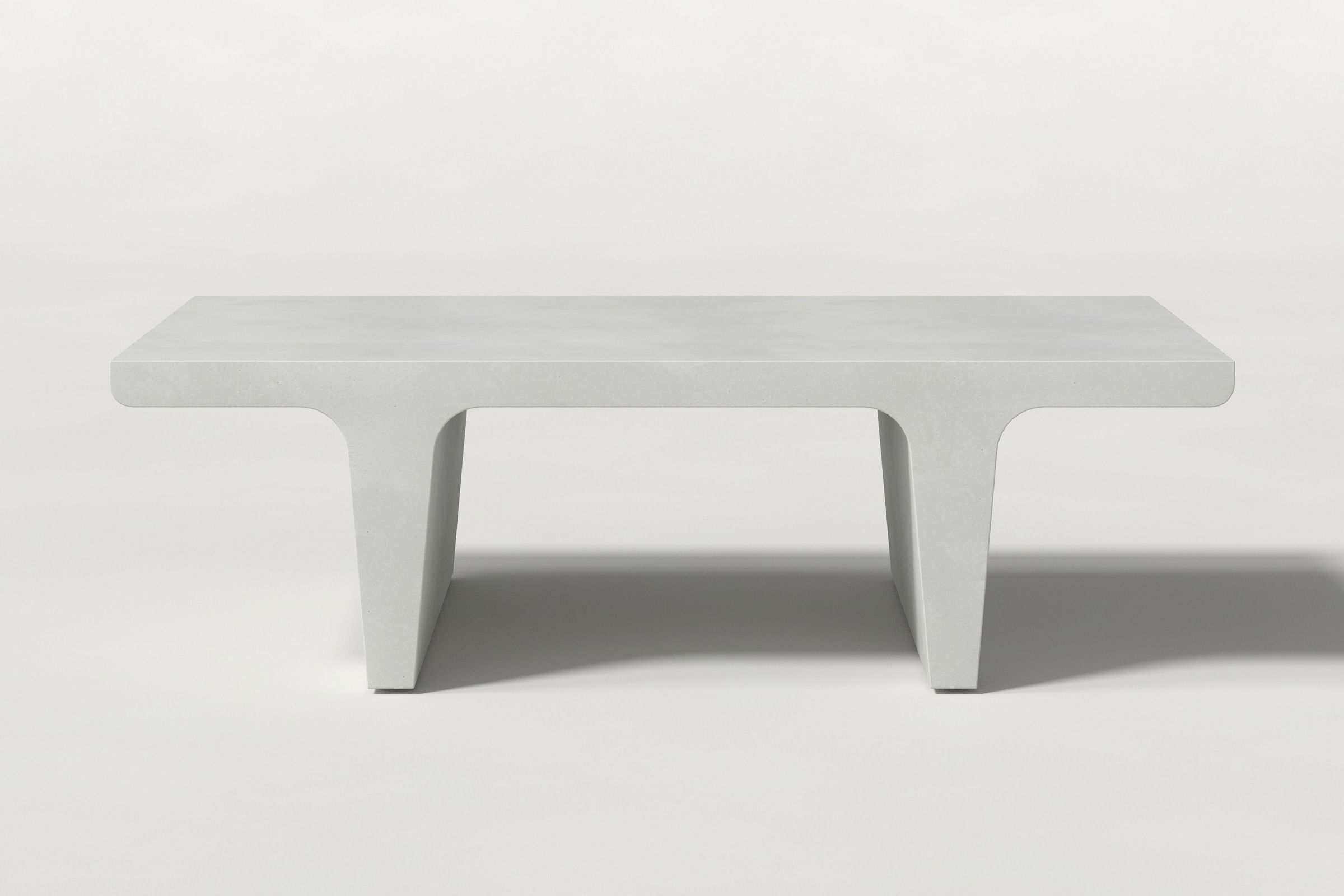 Rectangular solid white concrete coffee table with sculptural double tee legs and a smooth top, set against a clean white background.