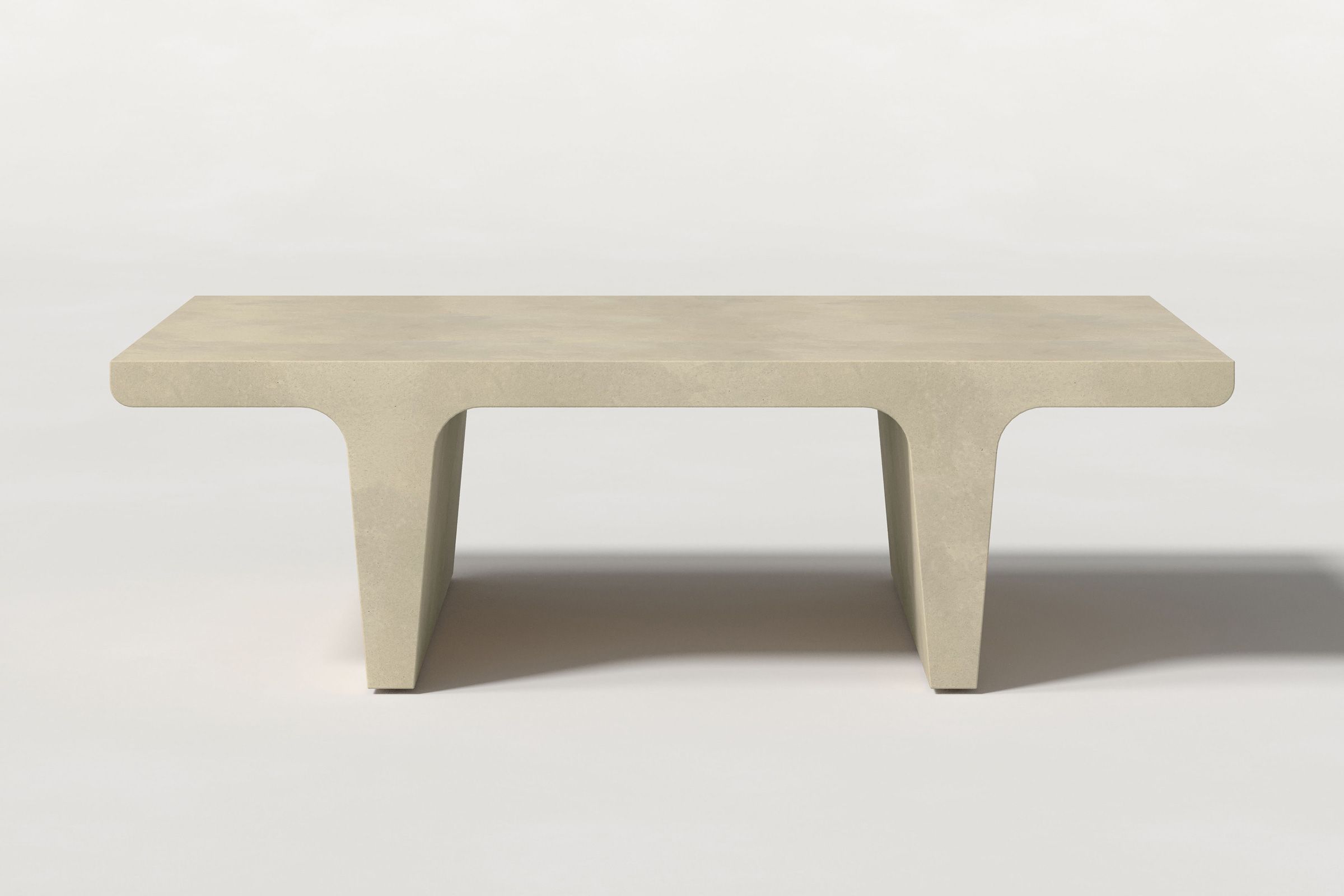 Rectangular solid light beige concrete coffee table with sculptural double tee legs and a smooth top, set against a clean white background.
