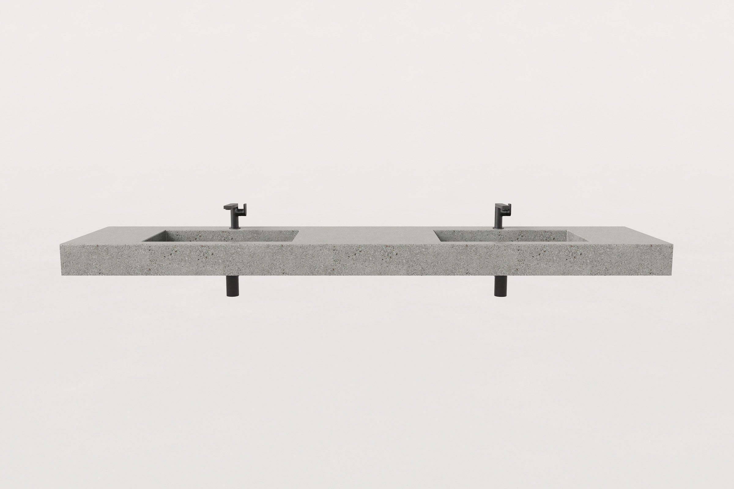 Front view of concrete double-basin sink with two matte black faucets and drain pipes visible.