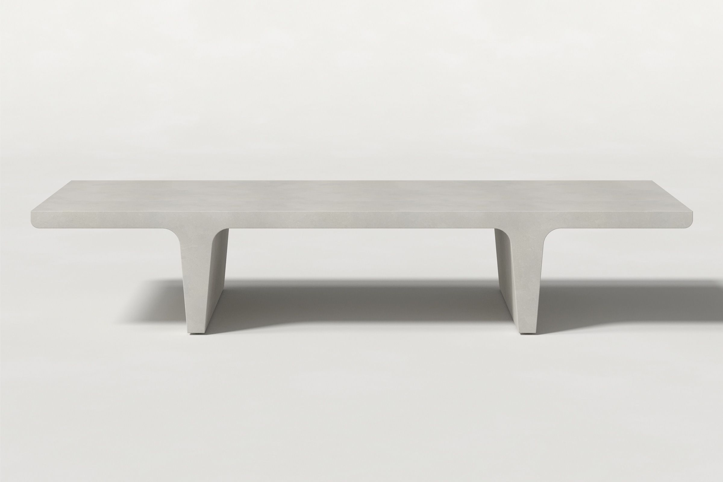 Rectangular solid light grey concrete coffee table with sculptural double tee legs and a smooth top, set against a clean white background.