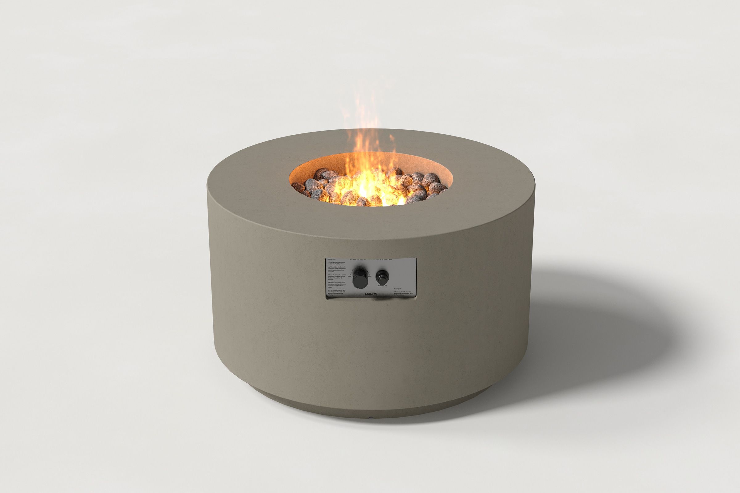 Low cylindrical dark grey colored concrete fire pit with thick walls and a central circular well filled with dark volcanic rocks and flame. Side view on a white background.