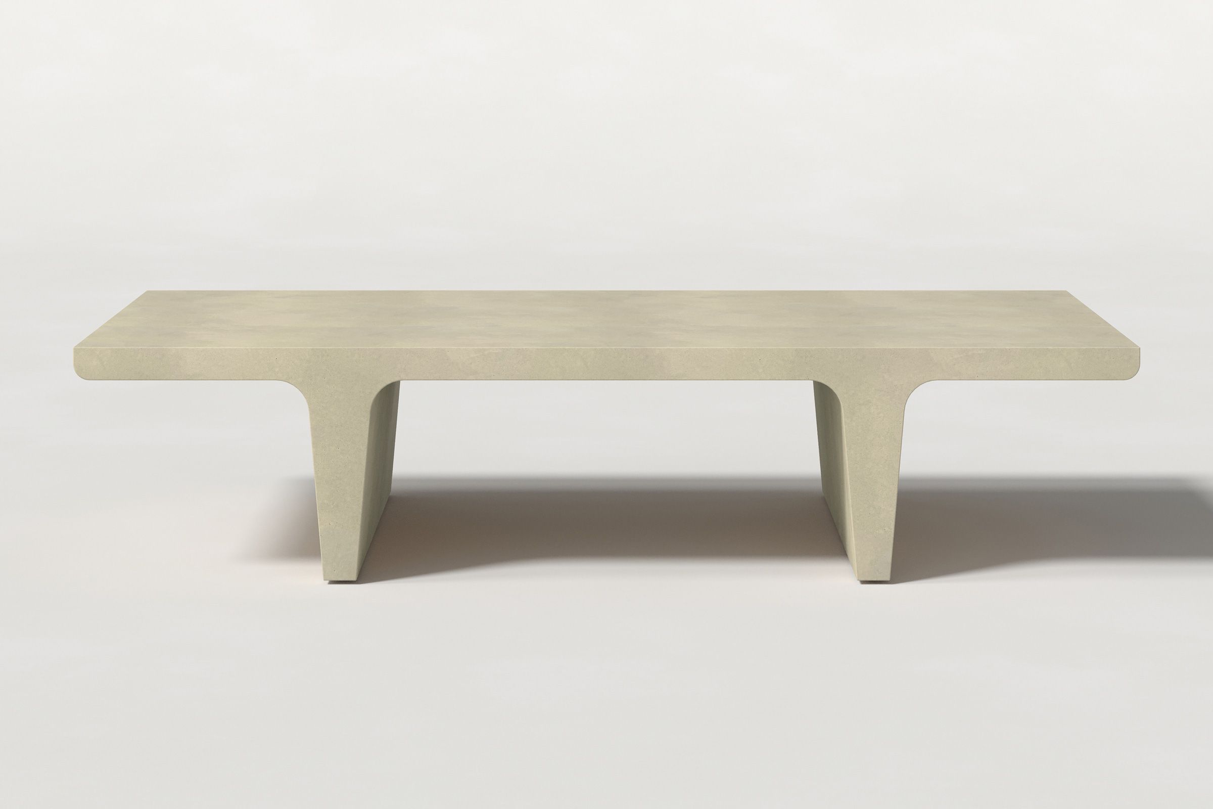 Rectangular solid light beige concrete coffee table with sculptural double tee legs and a smooth top, set against a clean white background.