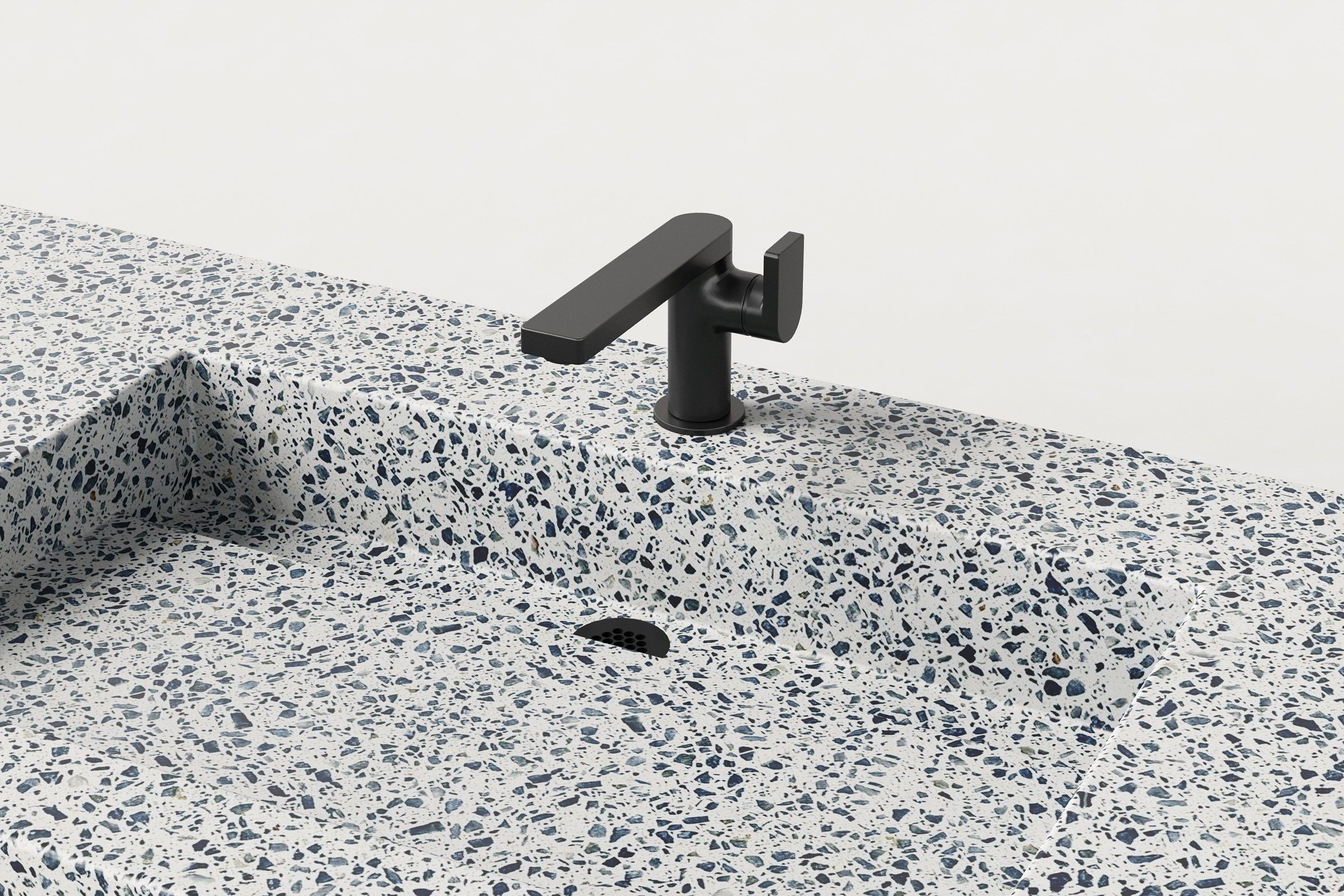 Detail close-up of Unazzo terrazzo sink showing integrated basin and black faucet.